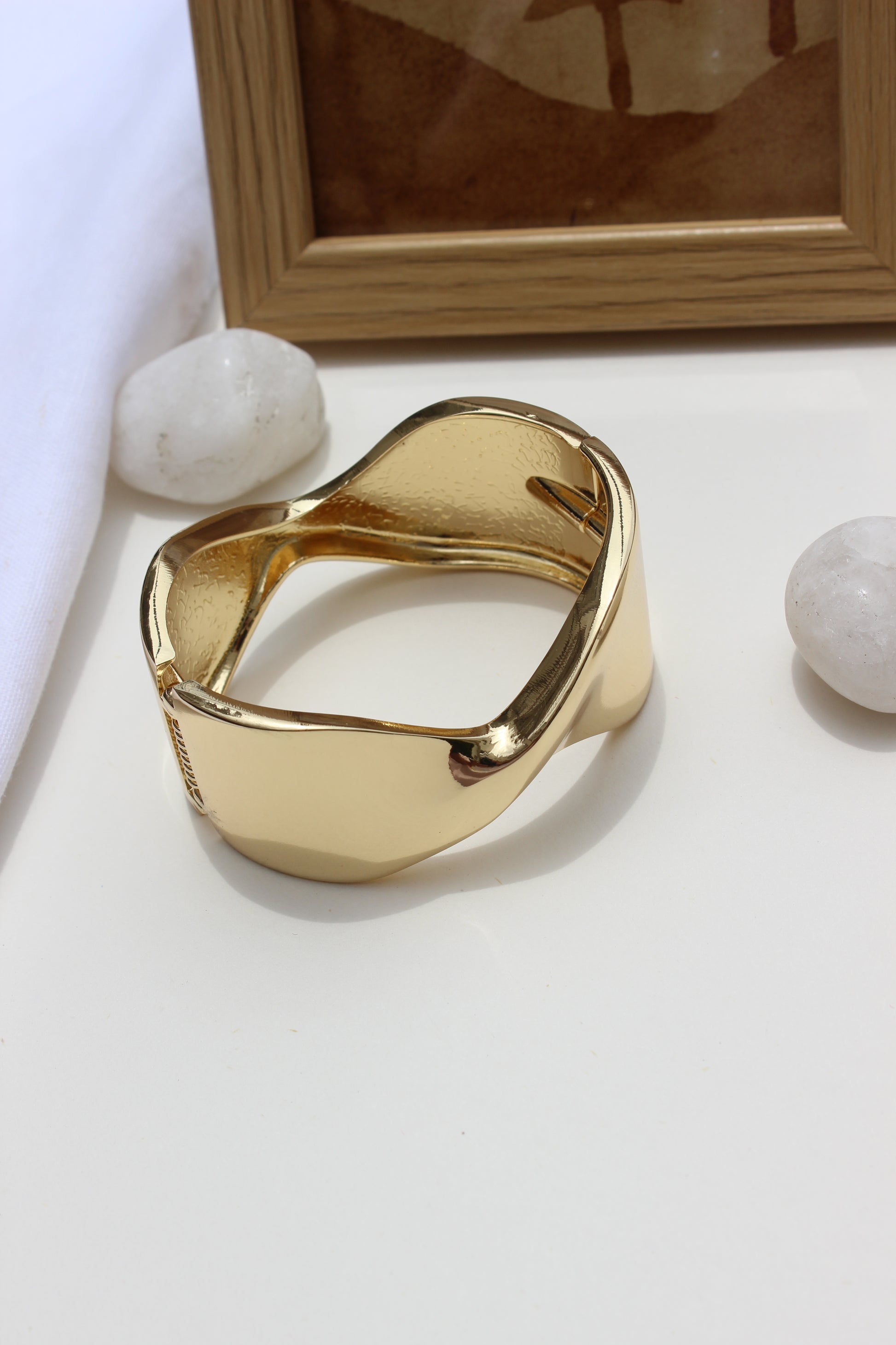 Molten Curve Bracelet on a white surface with a blurred background