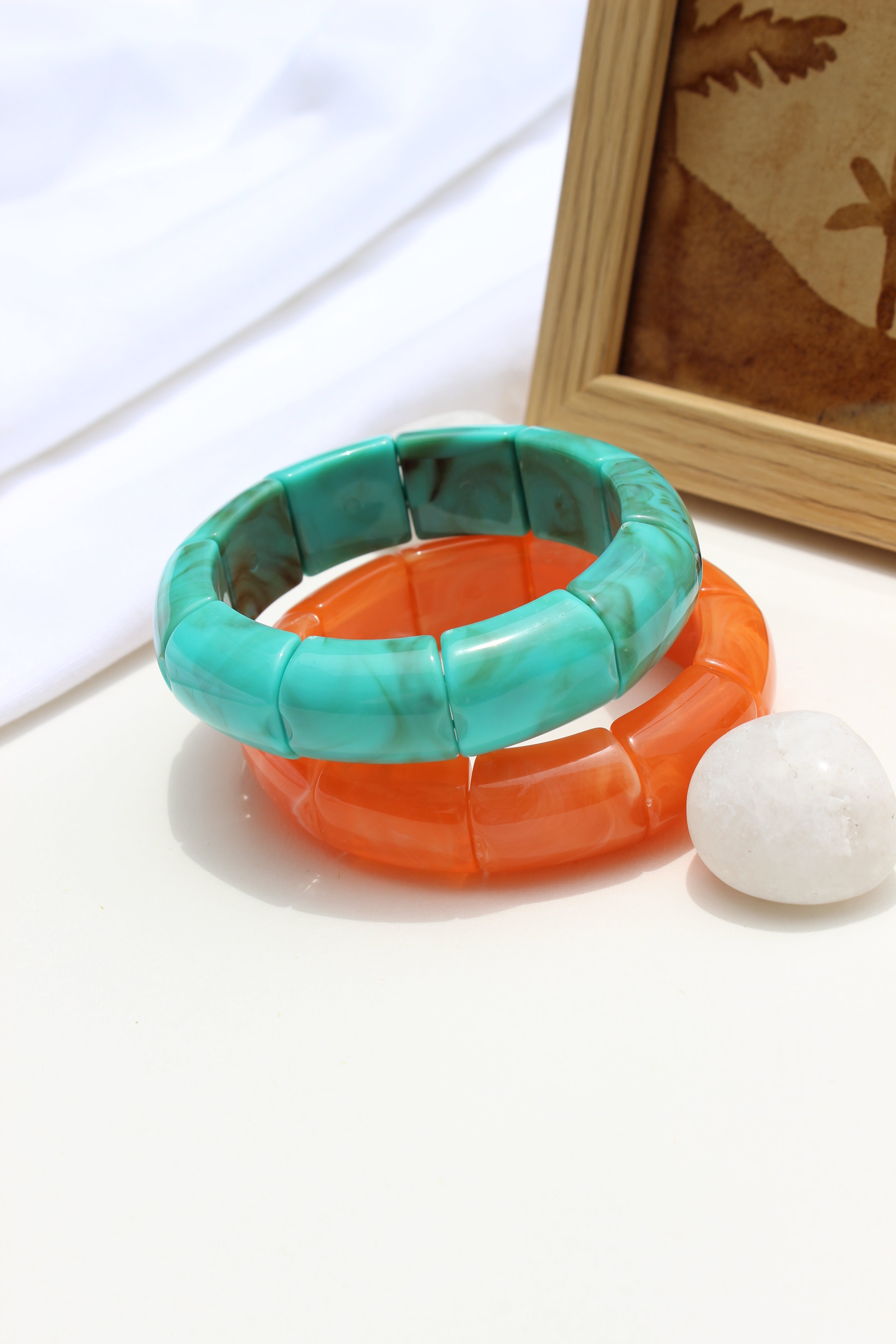 Peach Orbit Bangle Bracelets on a white surface with a blurred background