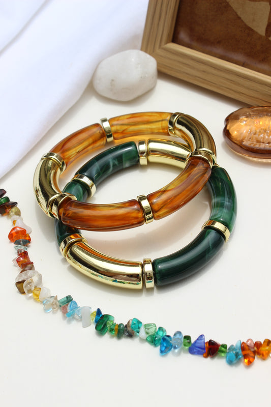 Amazonia Bangle Bracelets on a white surface with a marble stone and wooden frame