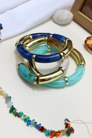 Colorhug Bangle Bracelets with gold accents on a white surface