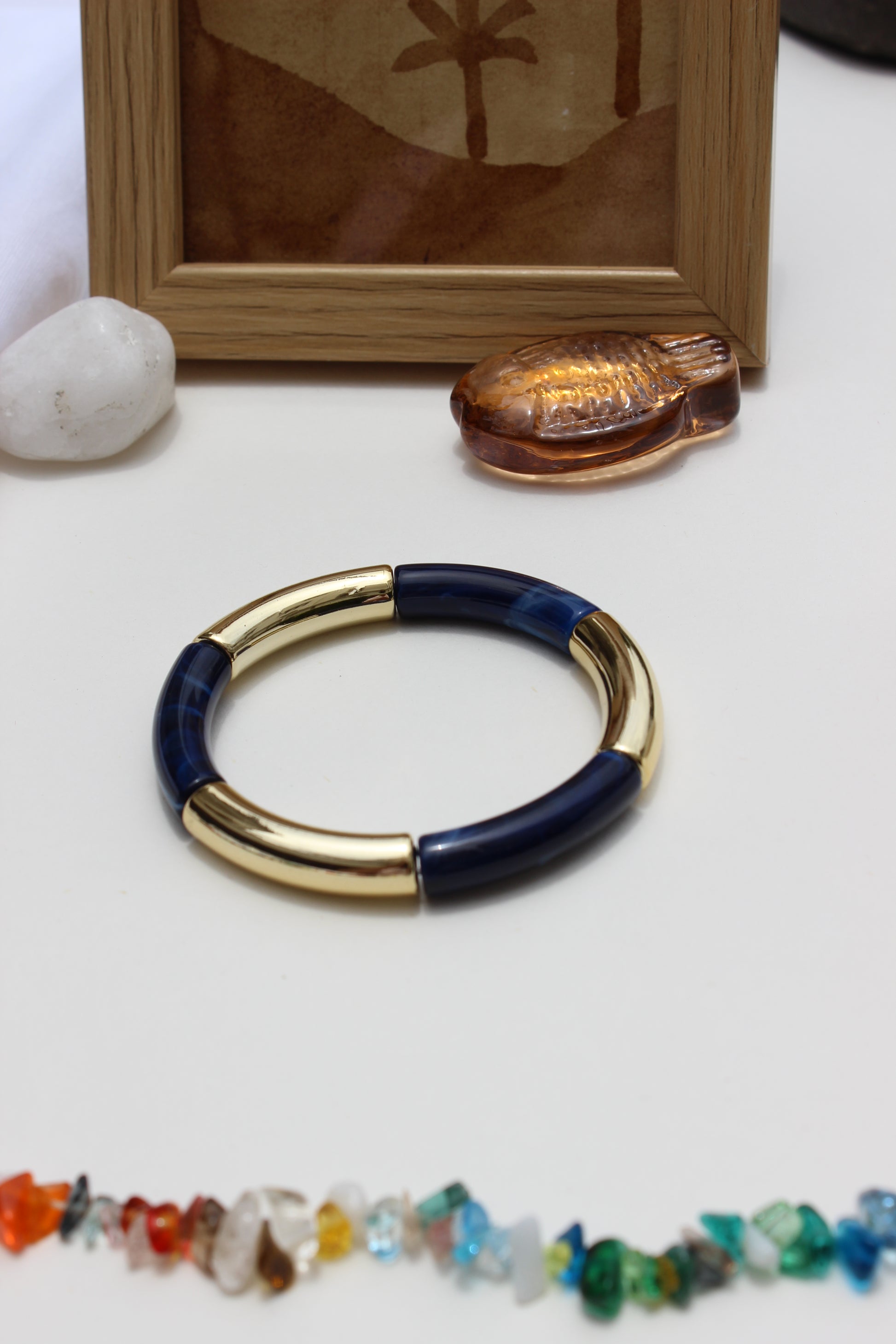Mistplay Bangle Bracelets on a white surface with a framed picture and colorful beads