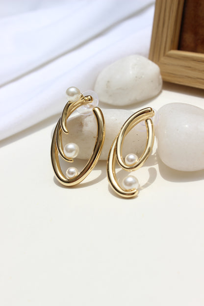 Not quite Twins Earrings on a white surface with stones and wooden frame