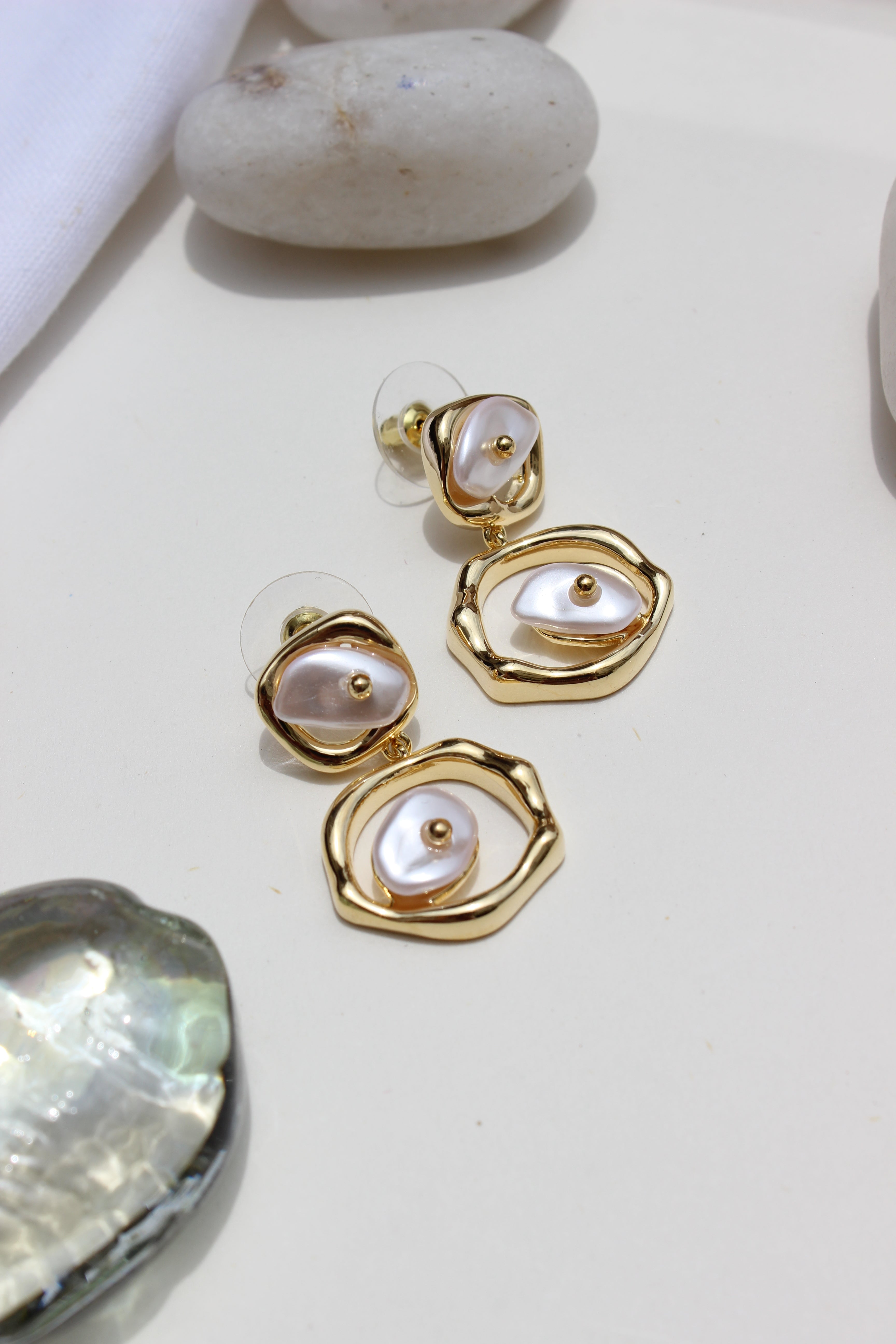 Sea of Silence Earrings on a light background with shells