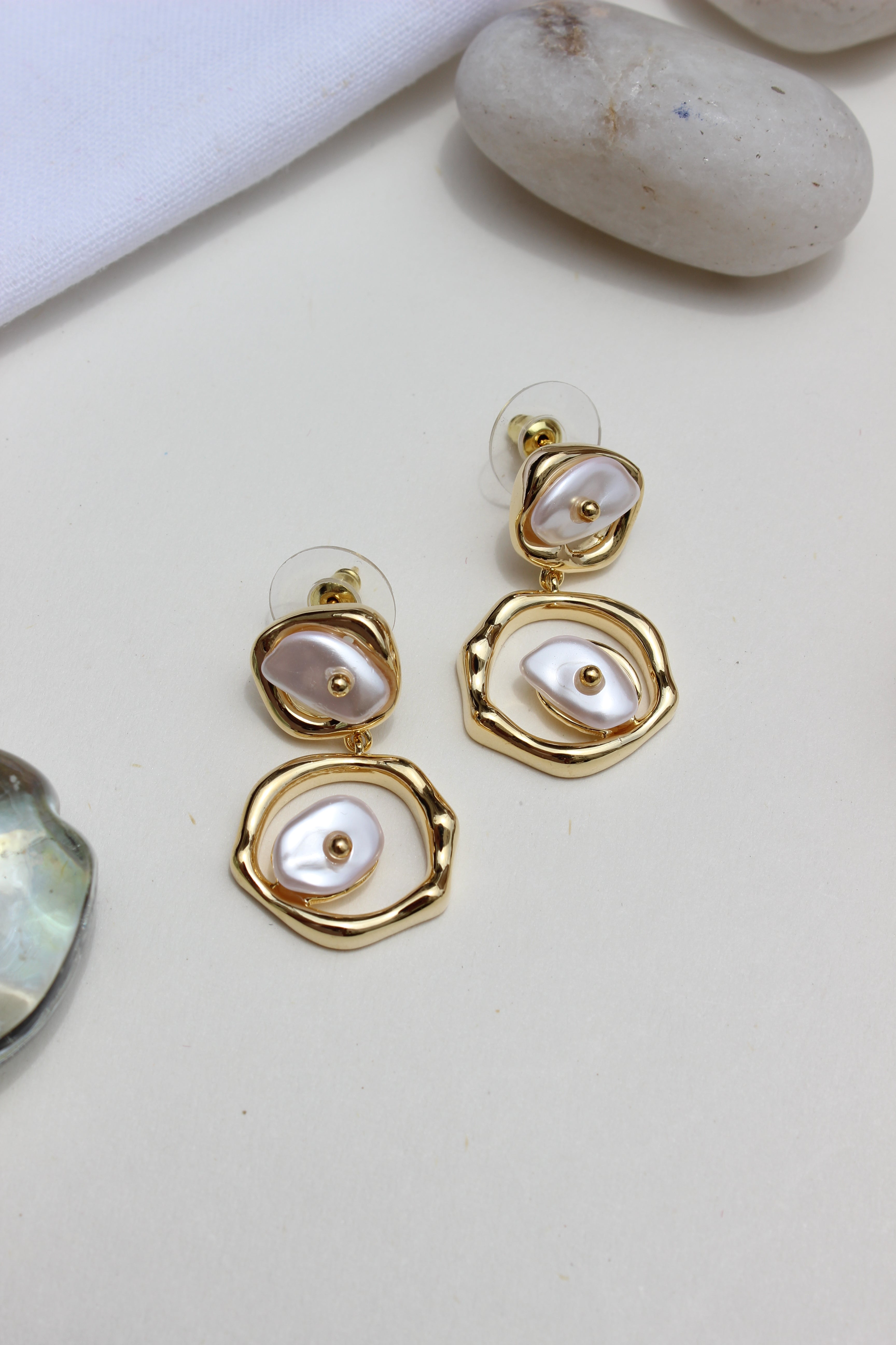 Sea of Silence Earrings with pearl-like stones on a light background