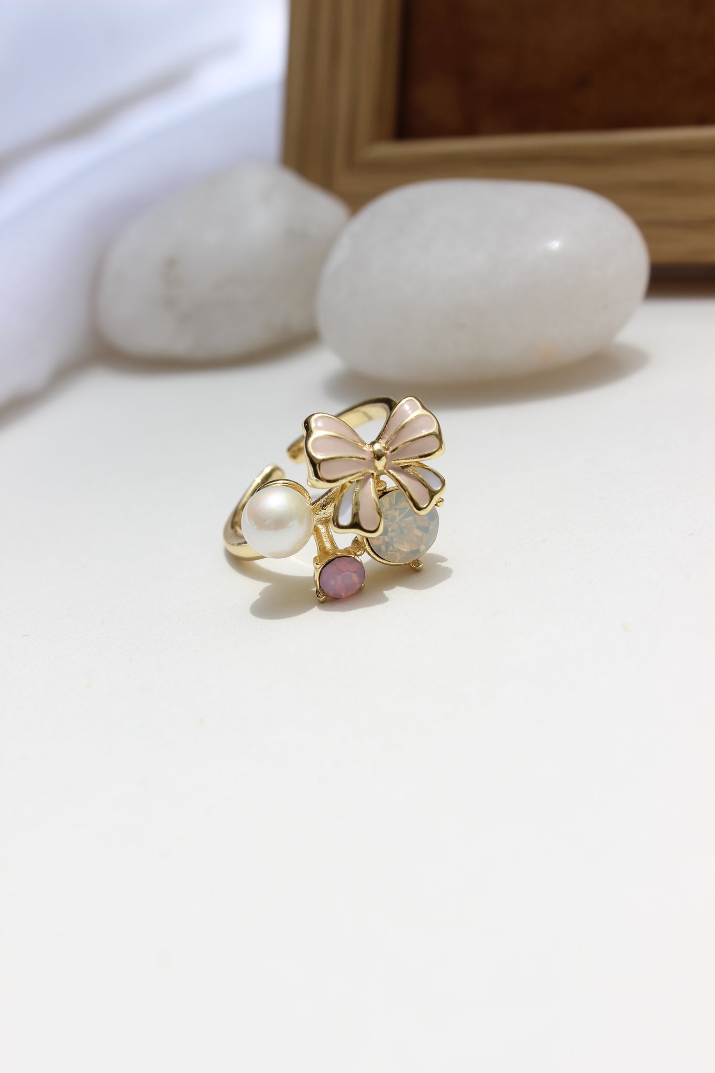 Saltbloom Ring with floral design and pearl on a white surface