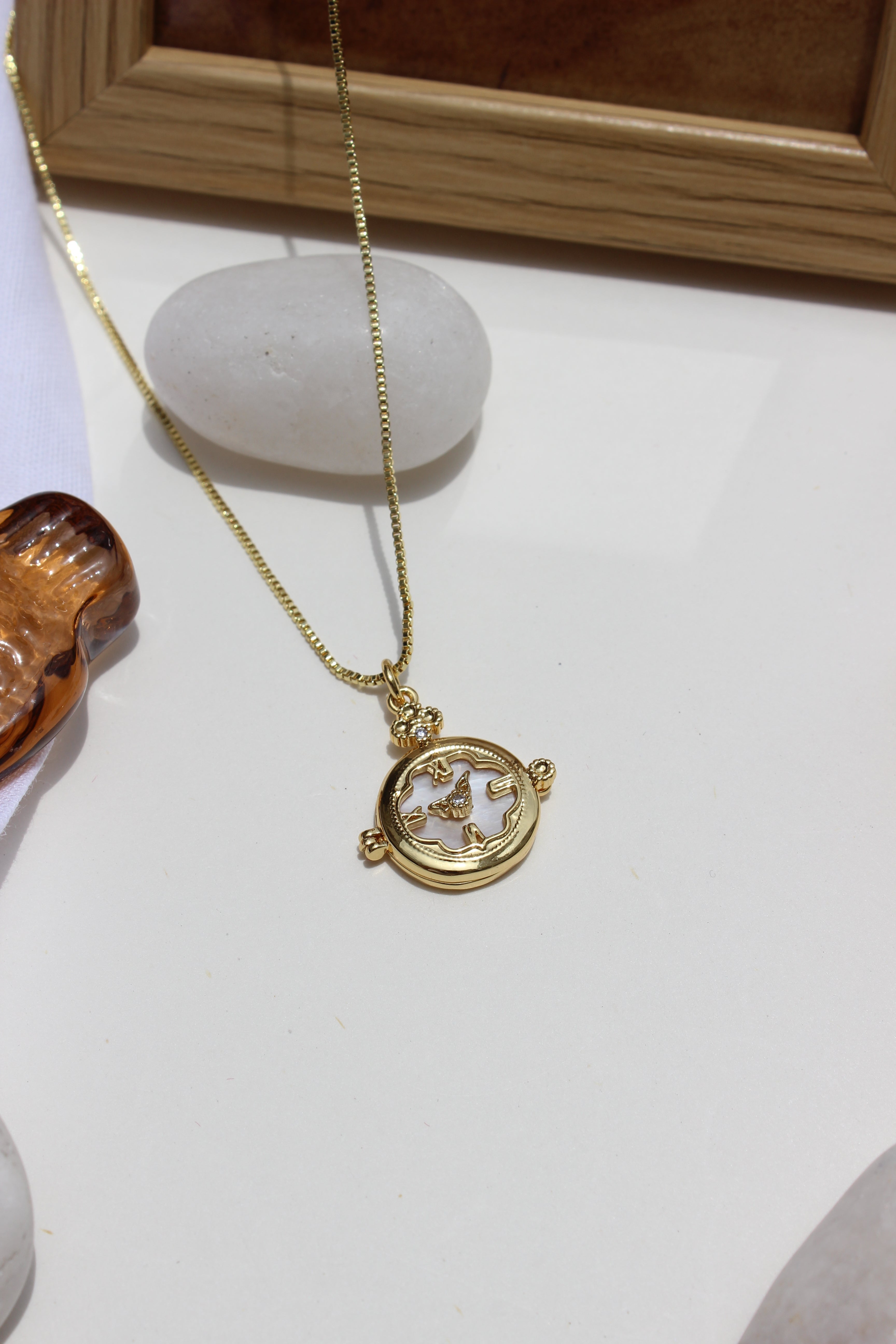 Whitespell Pendant Necklace with a decorative stones and shells on a white surface