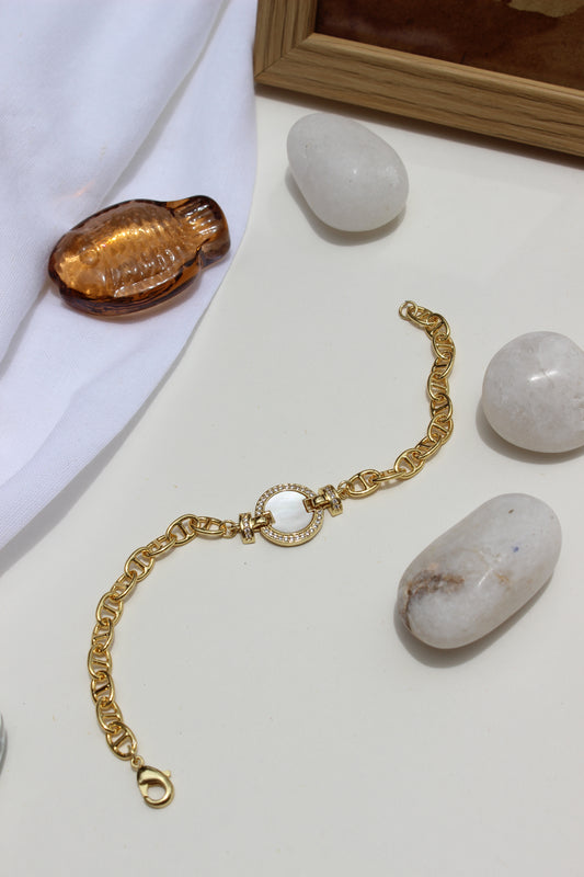 Sea of Light Bracelet on a white surface with stones and a wooden frame in the background