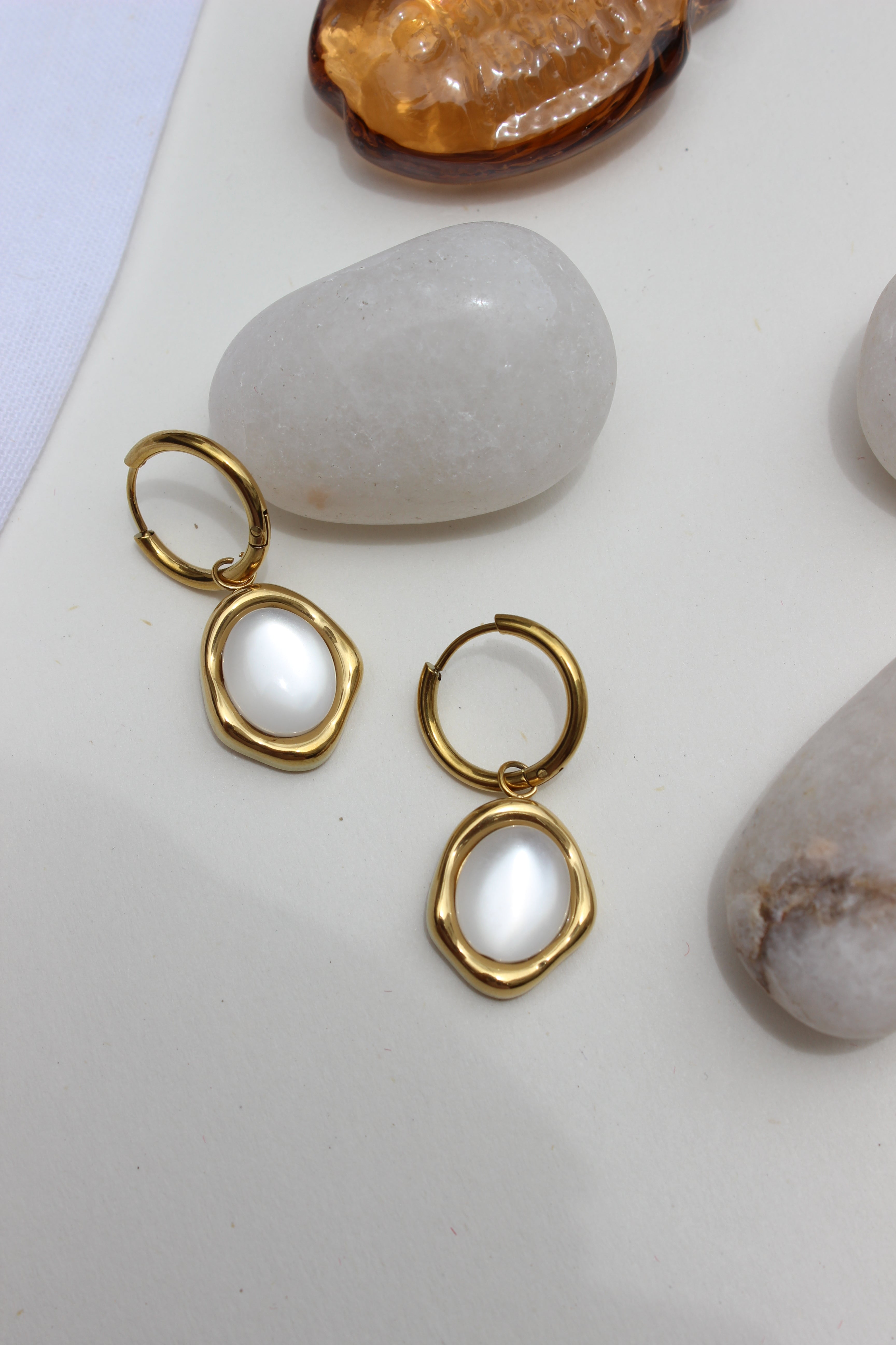 Stillwater Pearl Hoop Earrings with white stones on a light surface