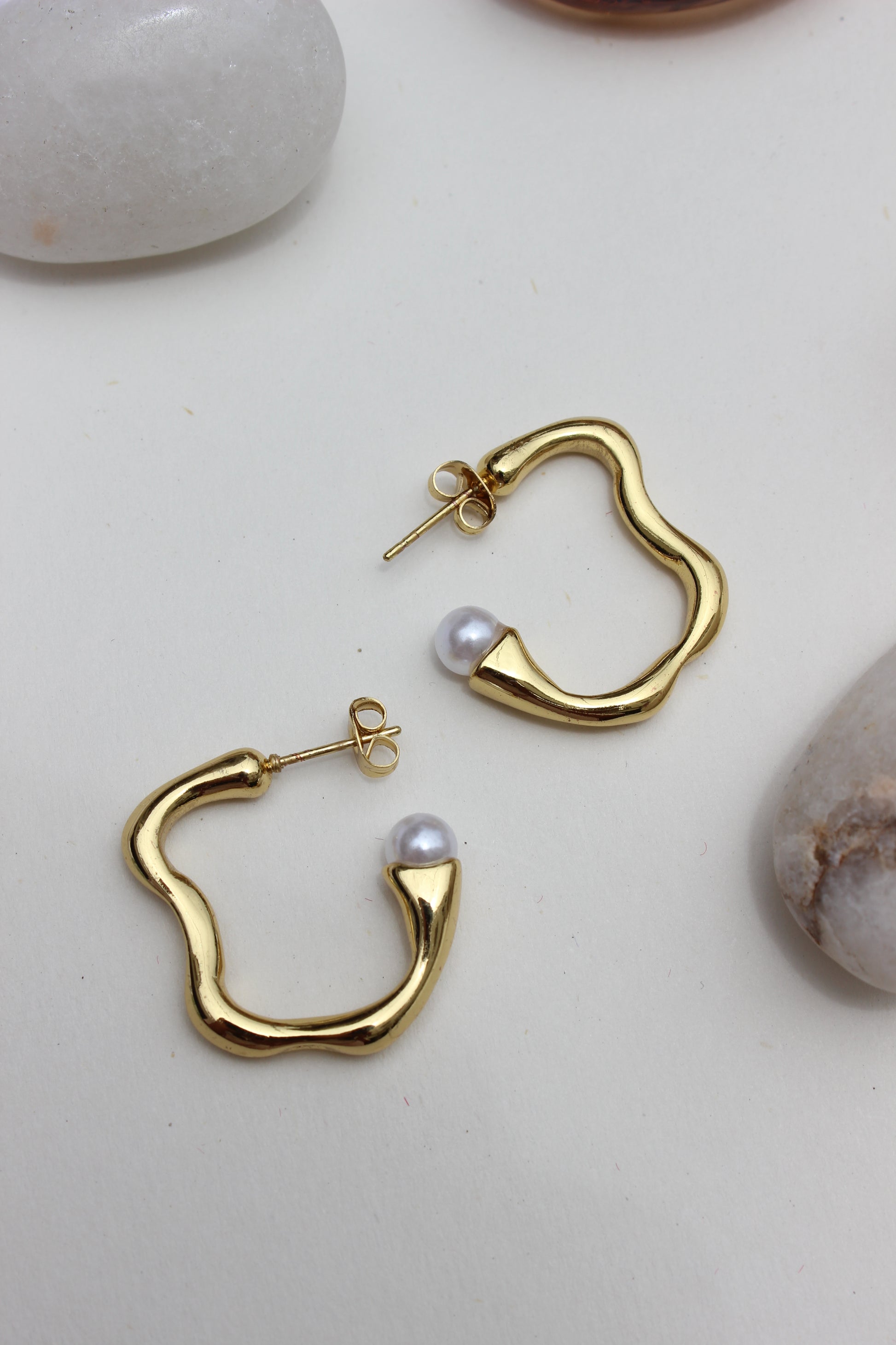 Pearl Fold Half Hoop Earrings on a light background