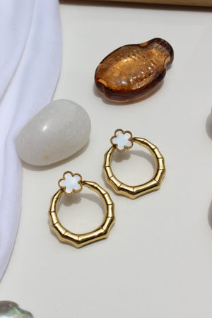 Moon Blossom Earrings with a central white stone on a light background