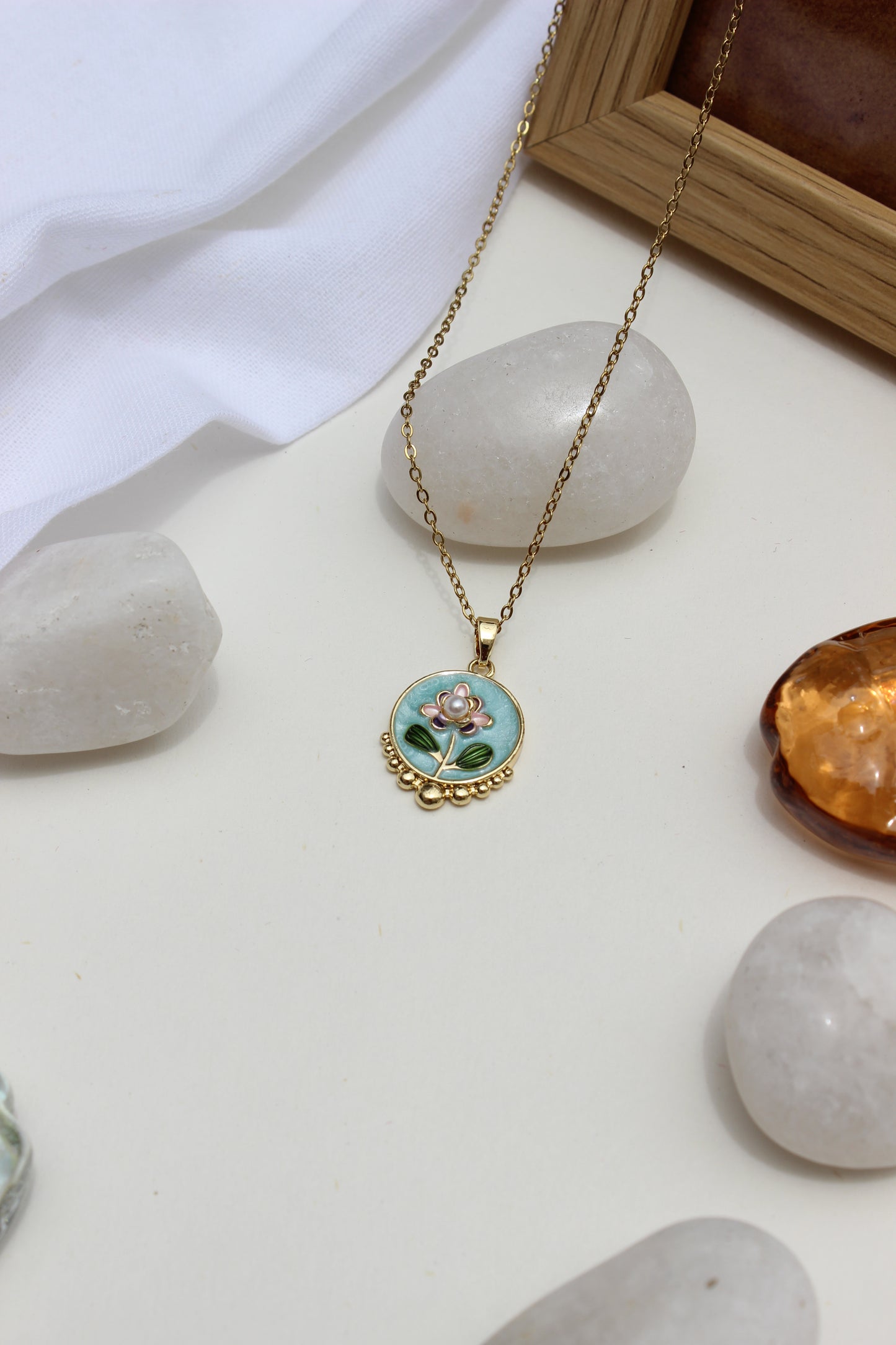 Skyflower Pendant Necklace on a white surface with stones