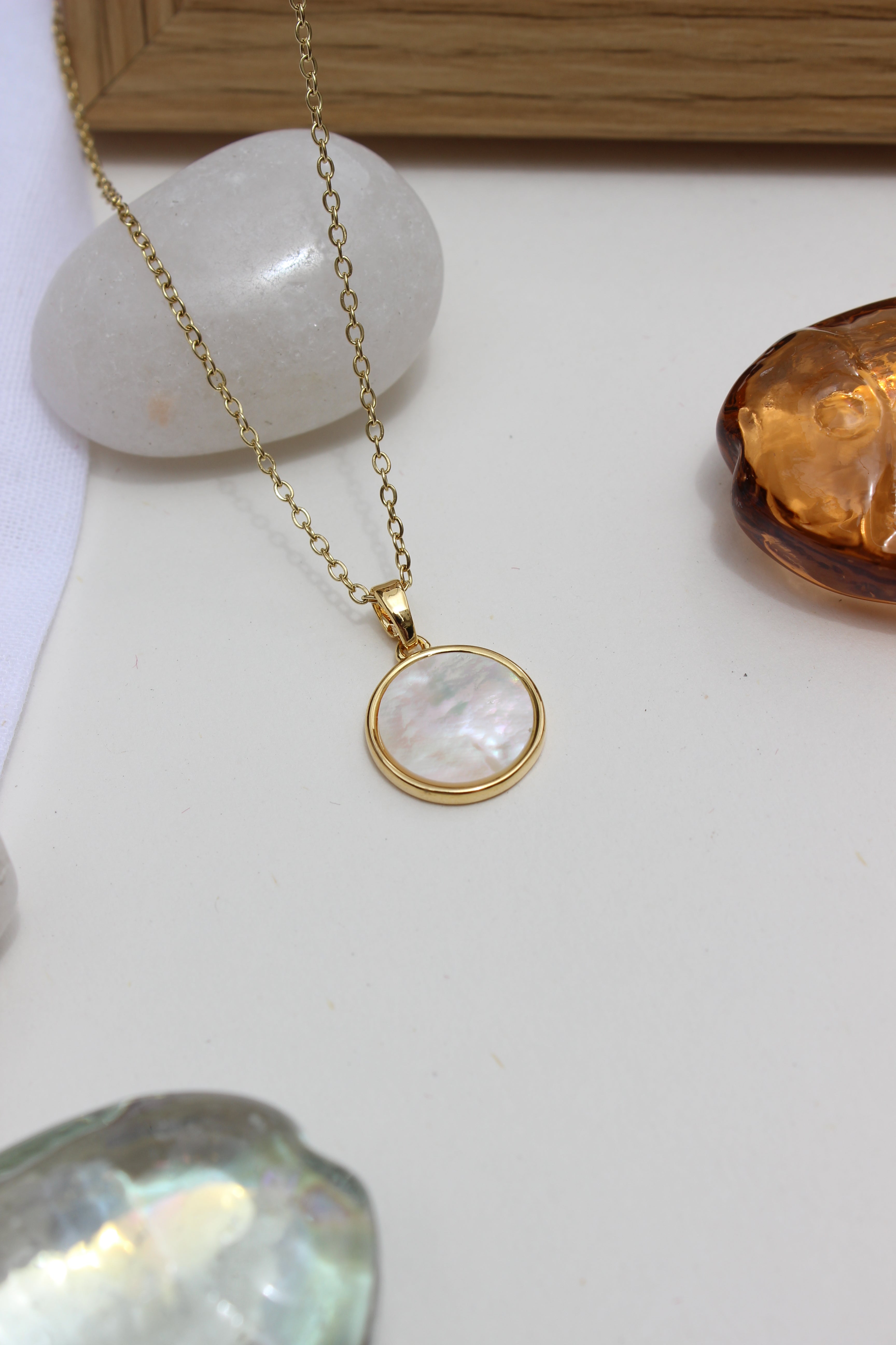 Melted Calm Pendant Necklace on a white surface with stones