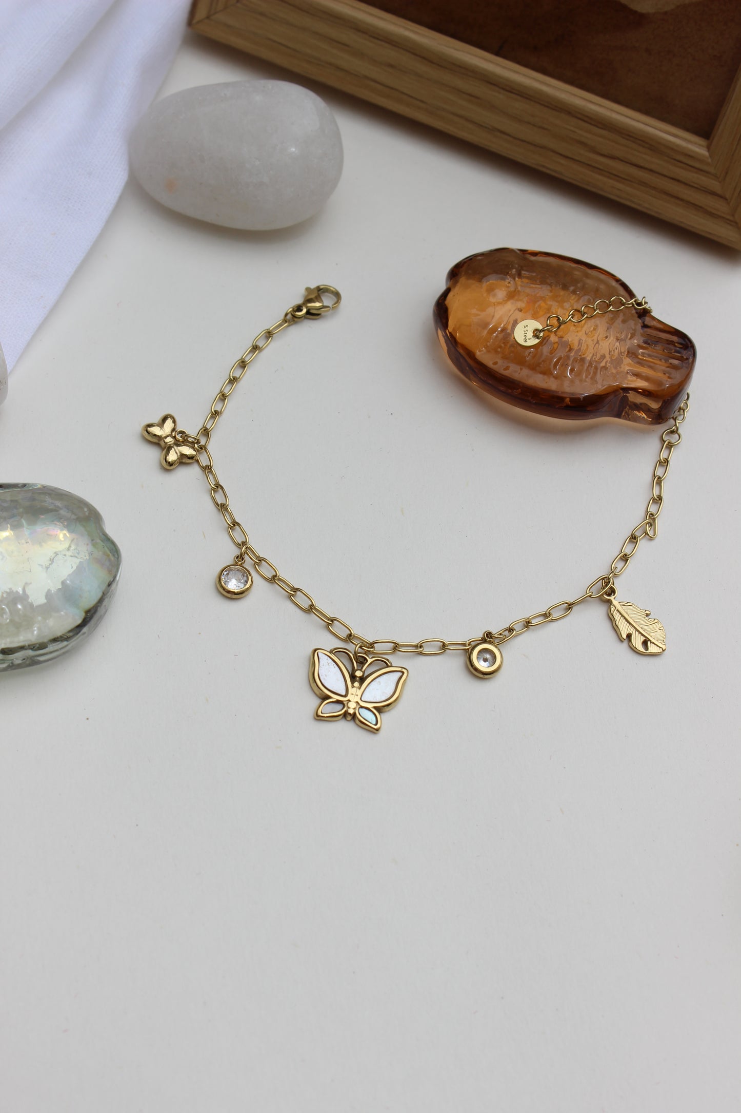 Honey & Moonlight Charm Bracelet on a white surface with stones