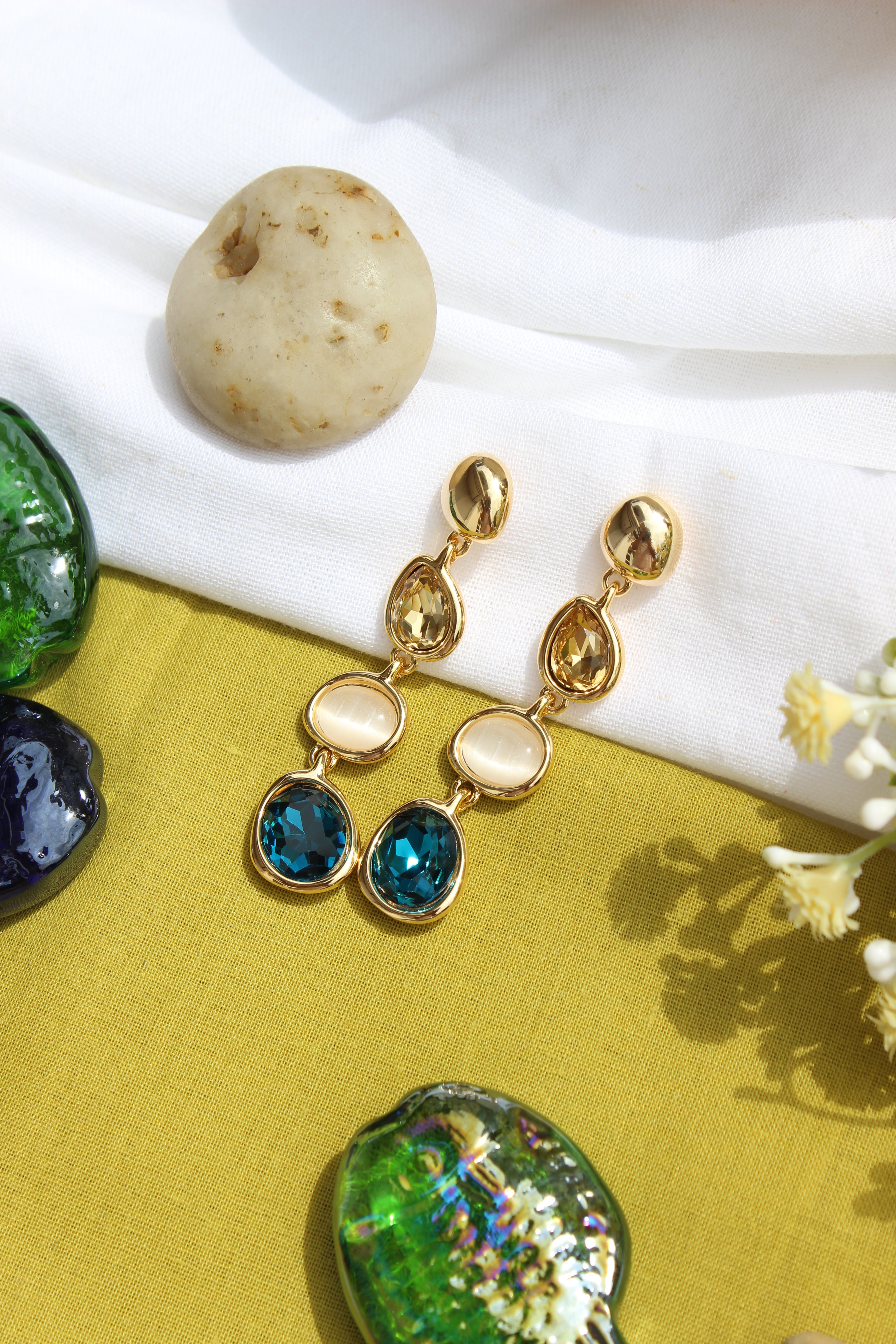 Blueberry Flame Earrings on a white and green fabric background