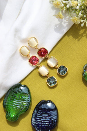 Skyfire Gleam Earrings on a yellow surface with decorative items