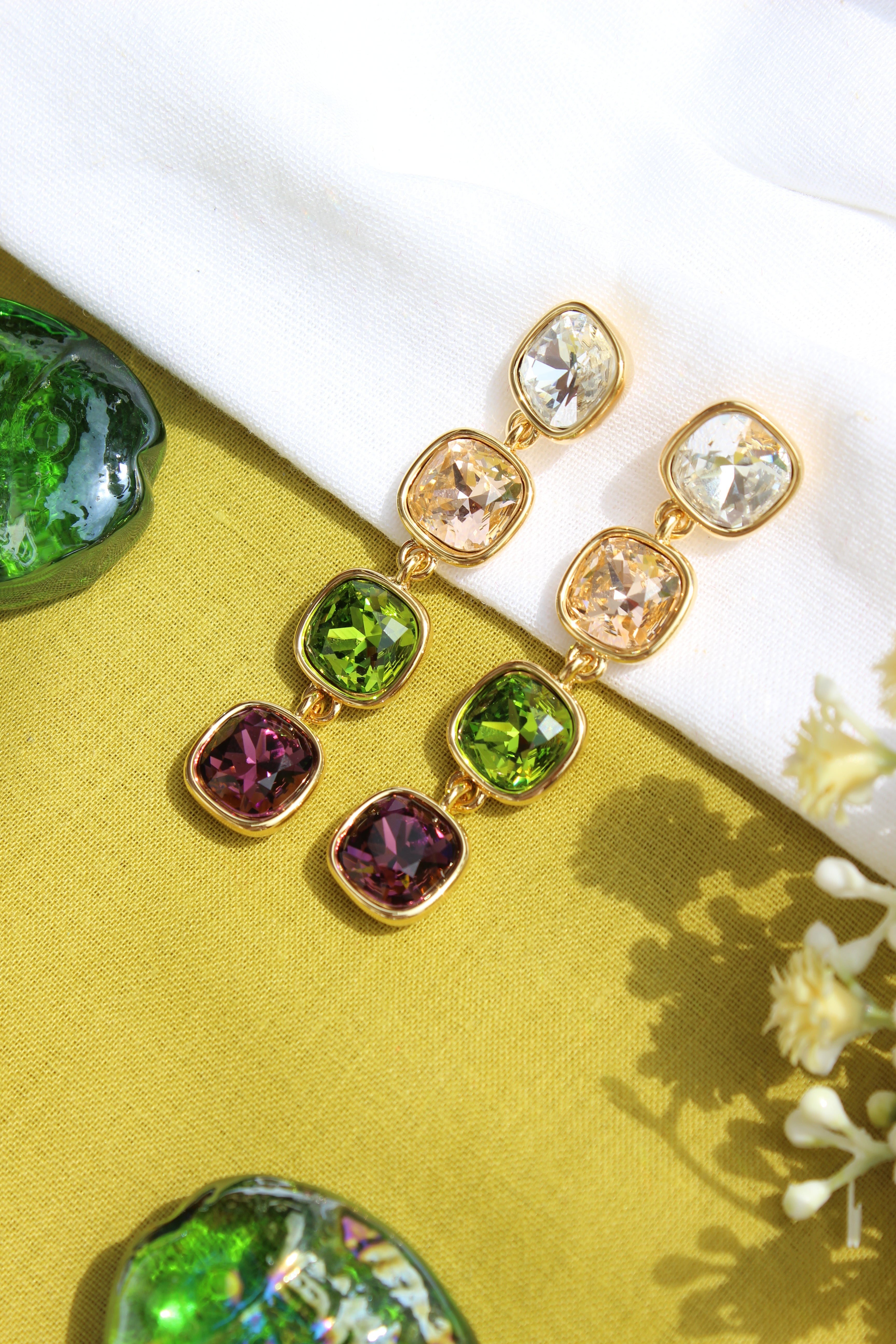 Moonkiss Drop Earrings on a yellow fabric background with flowers