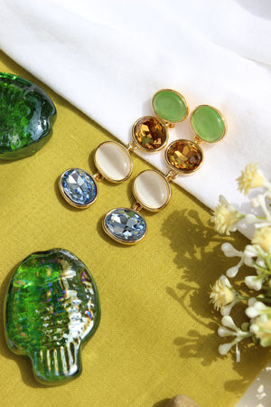 Gemstone Reverie Earrings on a yellow fabric background with flowers