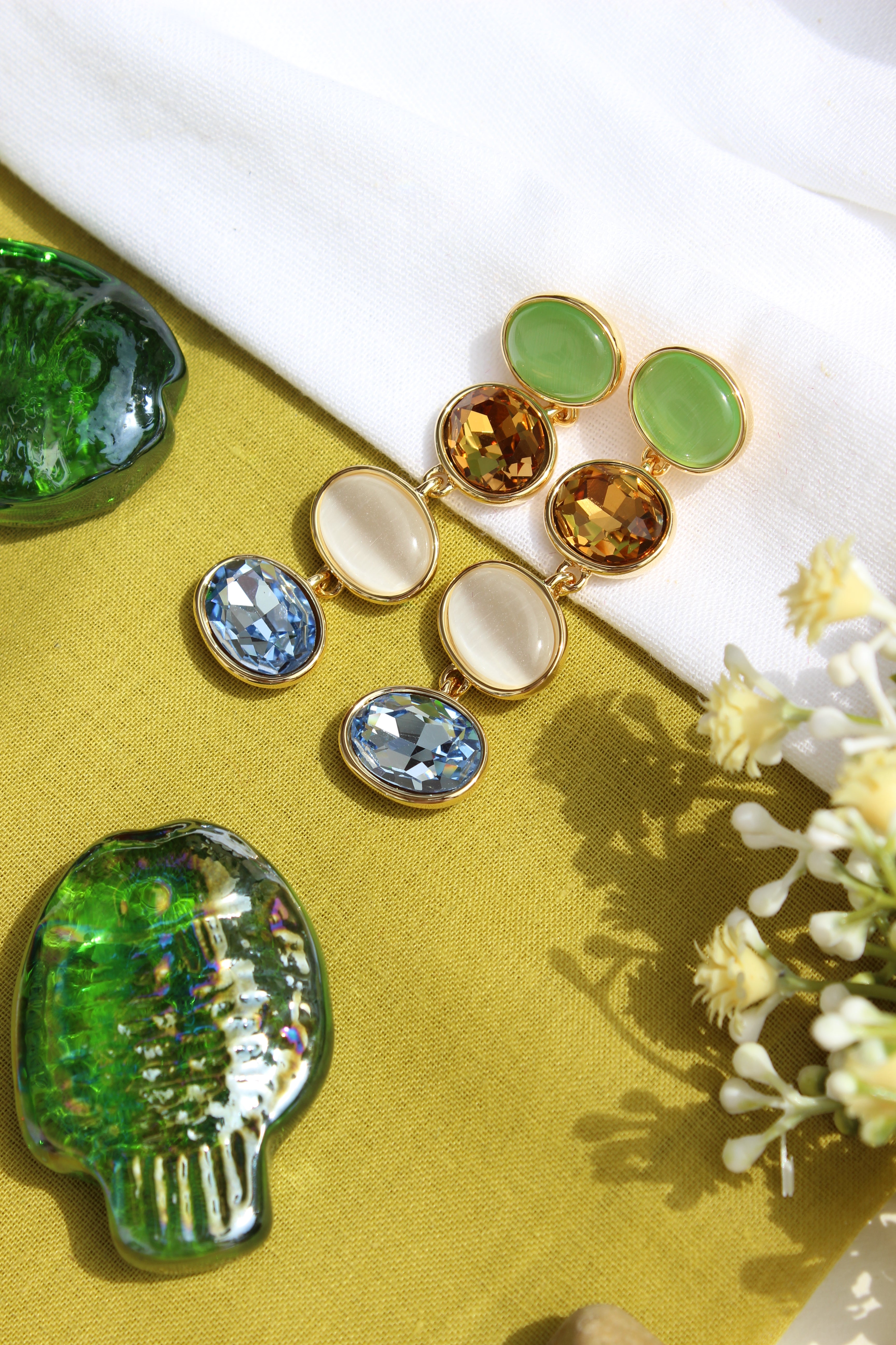 Gemstone Reverie Earrings on a yellow fabric background with flowers