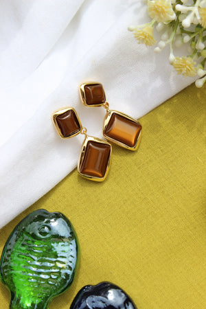 Amber Dust Earrings on a white and yellow fabric background