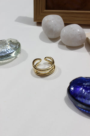Ember Ring on a white surface with decorative stones and a blue glass seashell