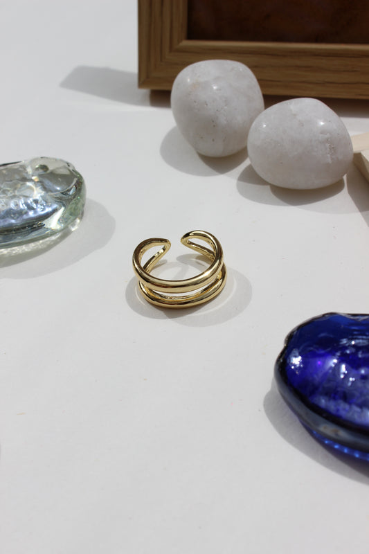 Ember Ring on a white surface with decorative stones and a blue glass seashell
