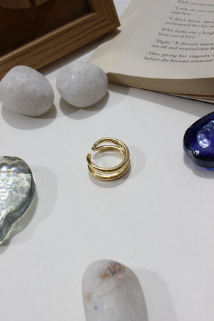 Ember Ring on a white surface with rocks and a book