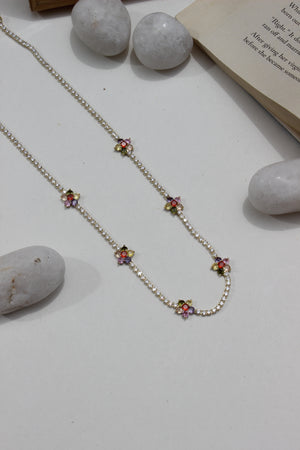 Floranta Necklace on a light surface with stones