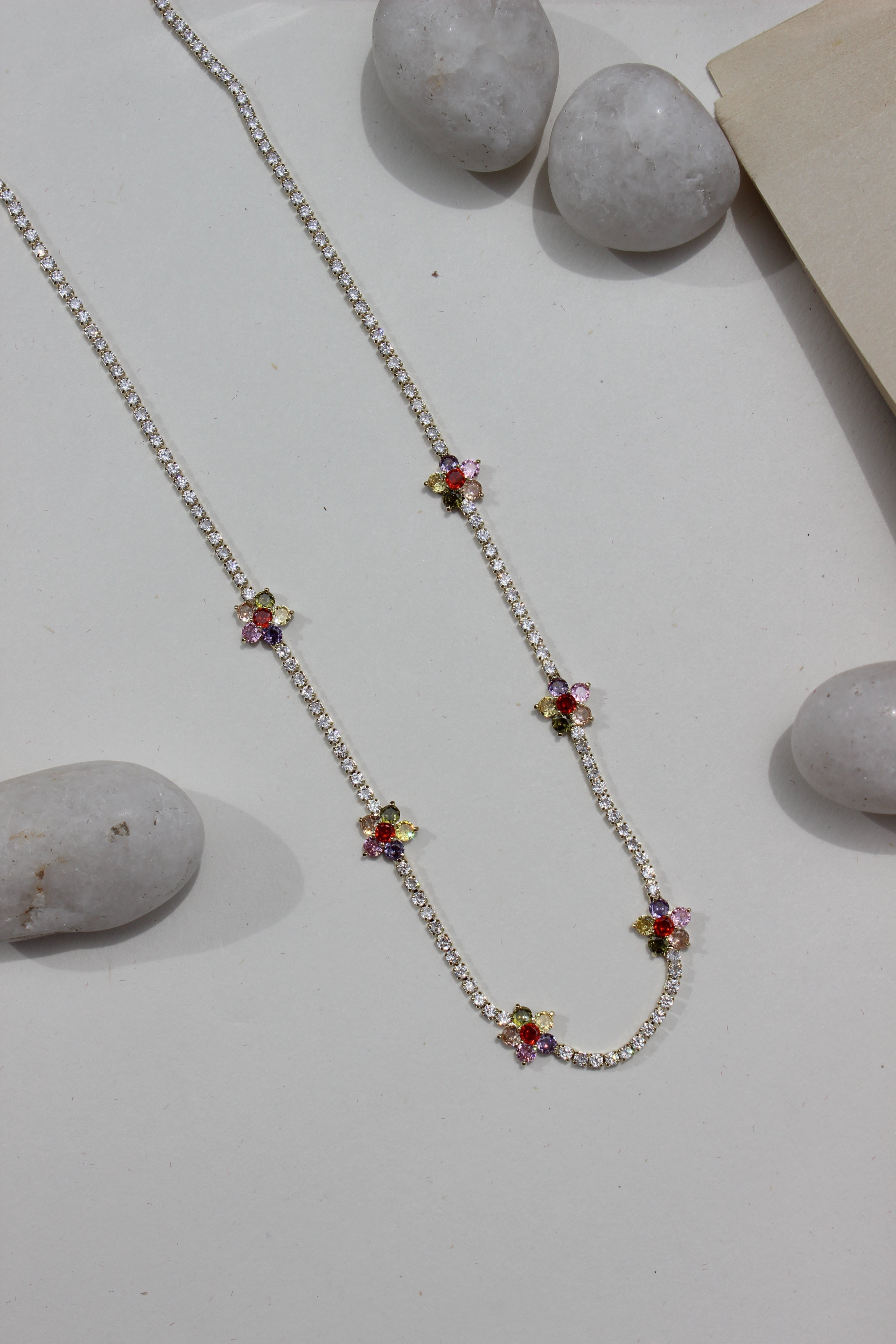 Floranta Necklace with colorful gemstones on a light surface with stones