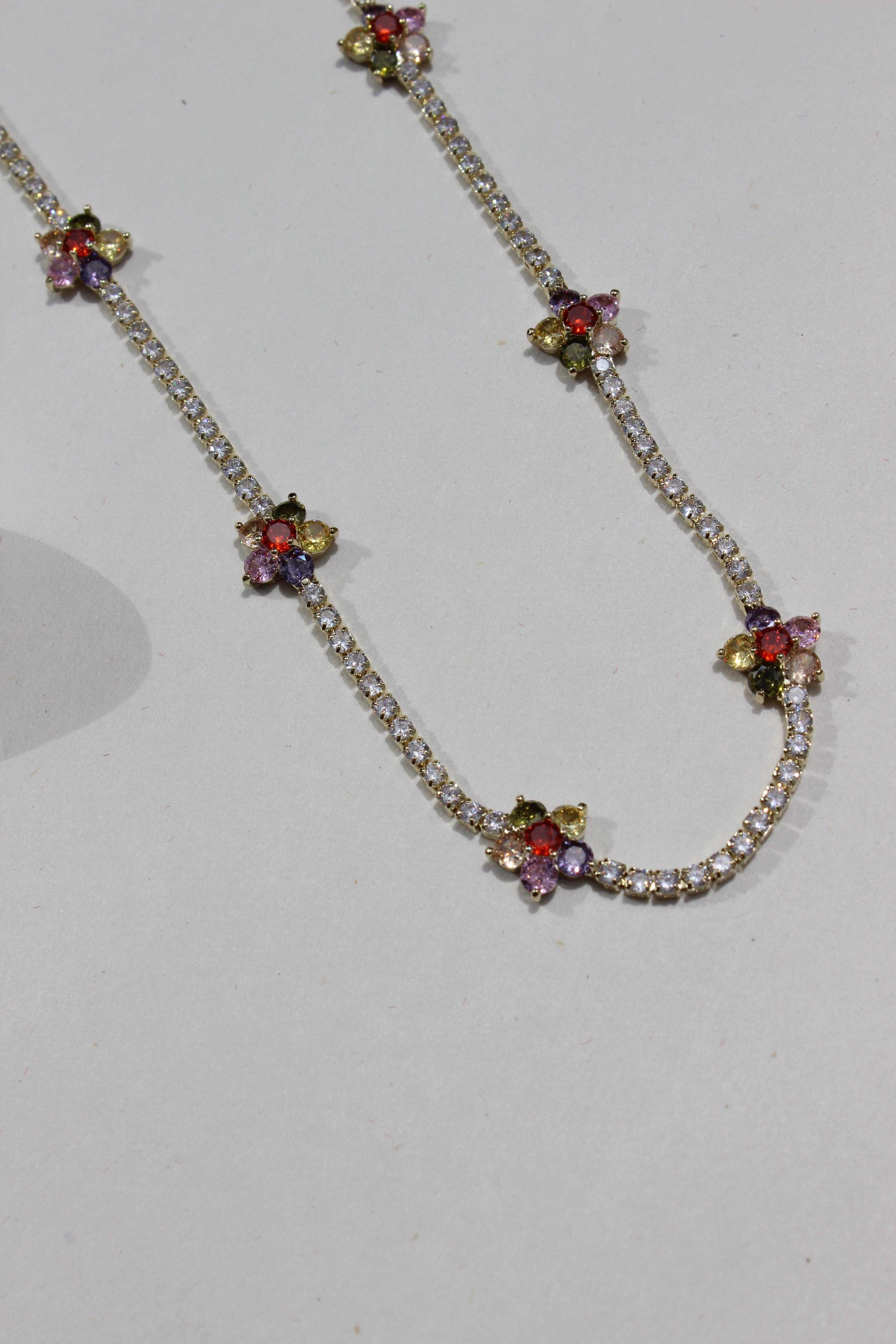 Floranta Necklace with floral designs and colorful stones on a white background