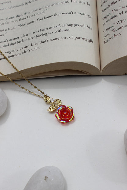 Primrose Dawn Pendant Necklace on an open book with a stone surface underneath