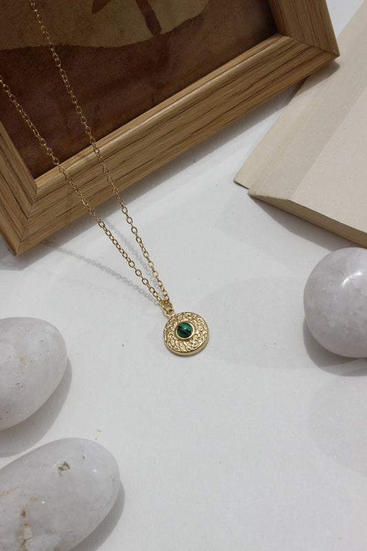 Forest Pulse Pendant Necklace on a light surface with stones and a wooden frame