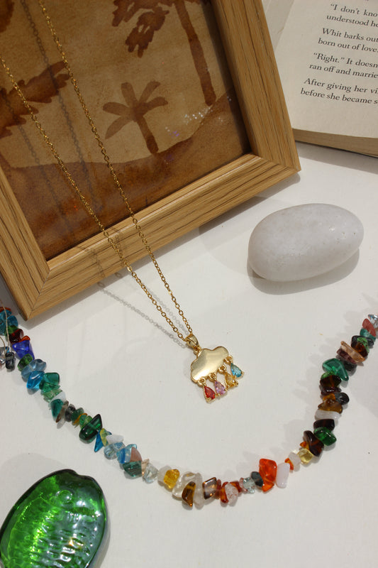 Skydrops Pendant Necklace on a white surface next to a wooden frame 