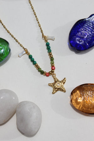 Star of Shore Necklace on a white surface with stones