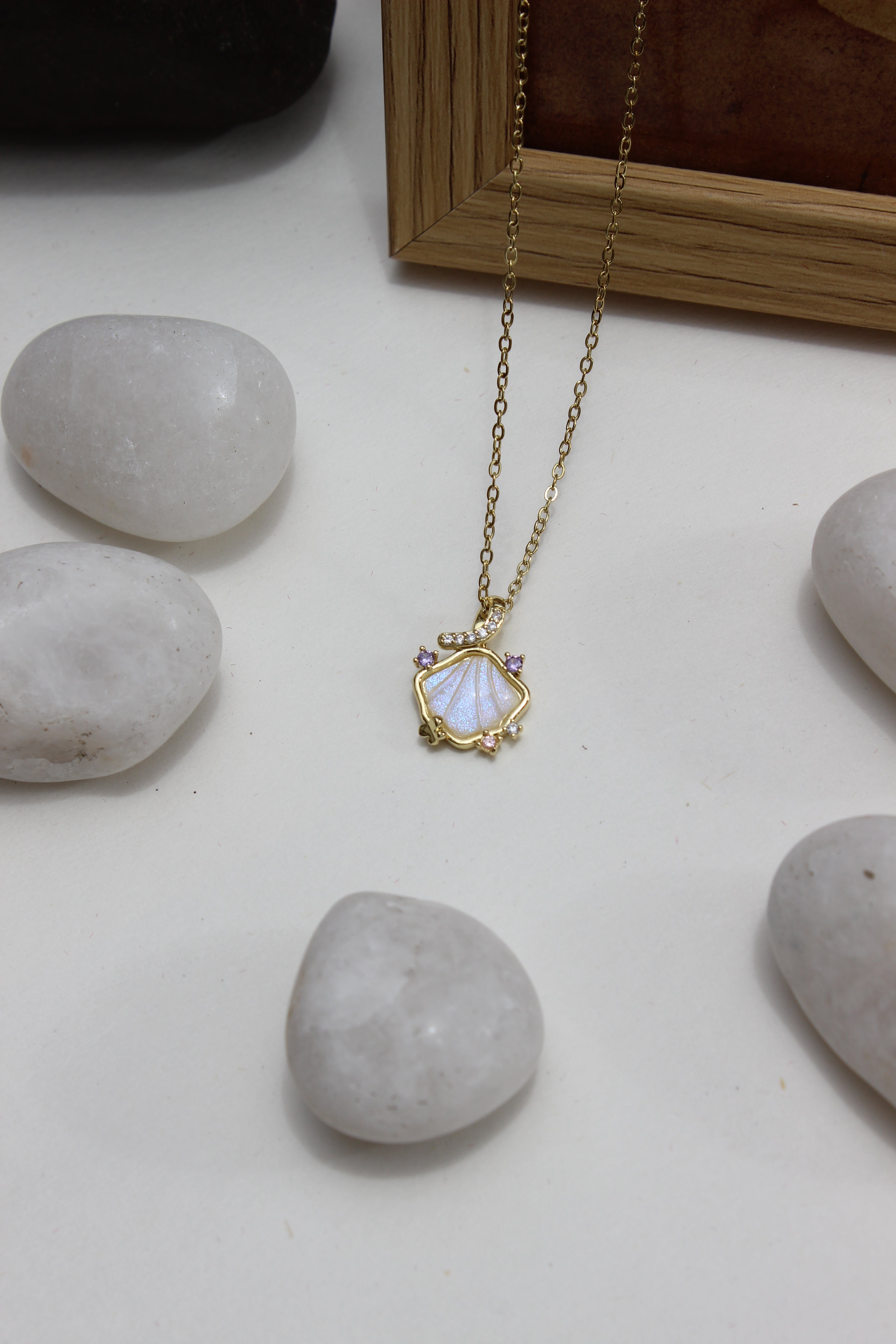 Heir to the Sea Pendant Necklace on pebbles