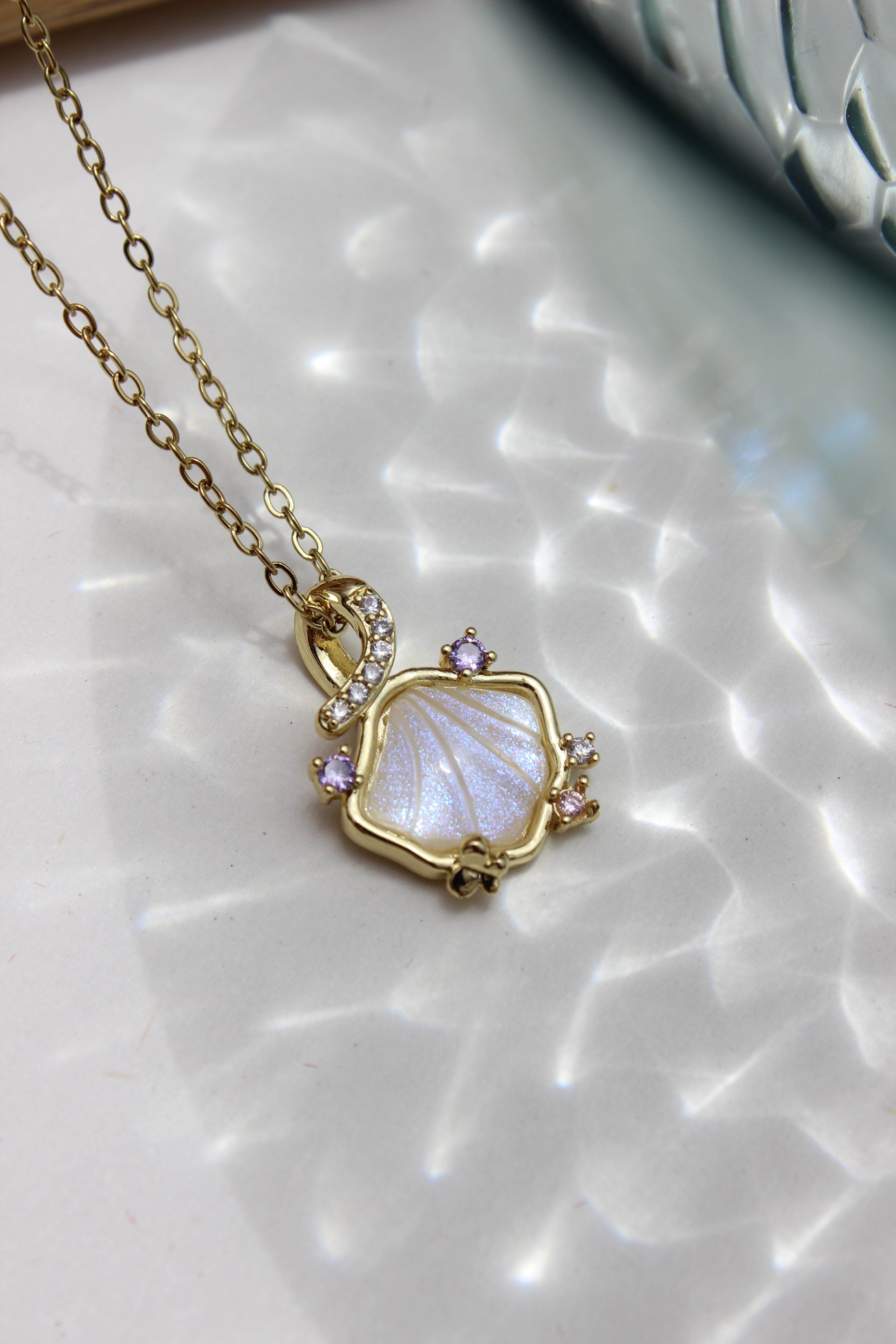 Heir to the Sea Pendant Necklace on a textured white surface