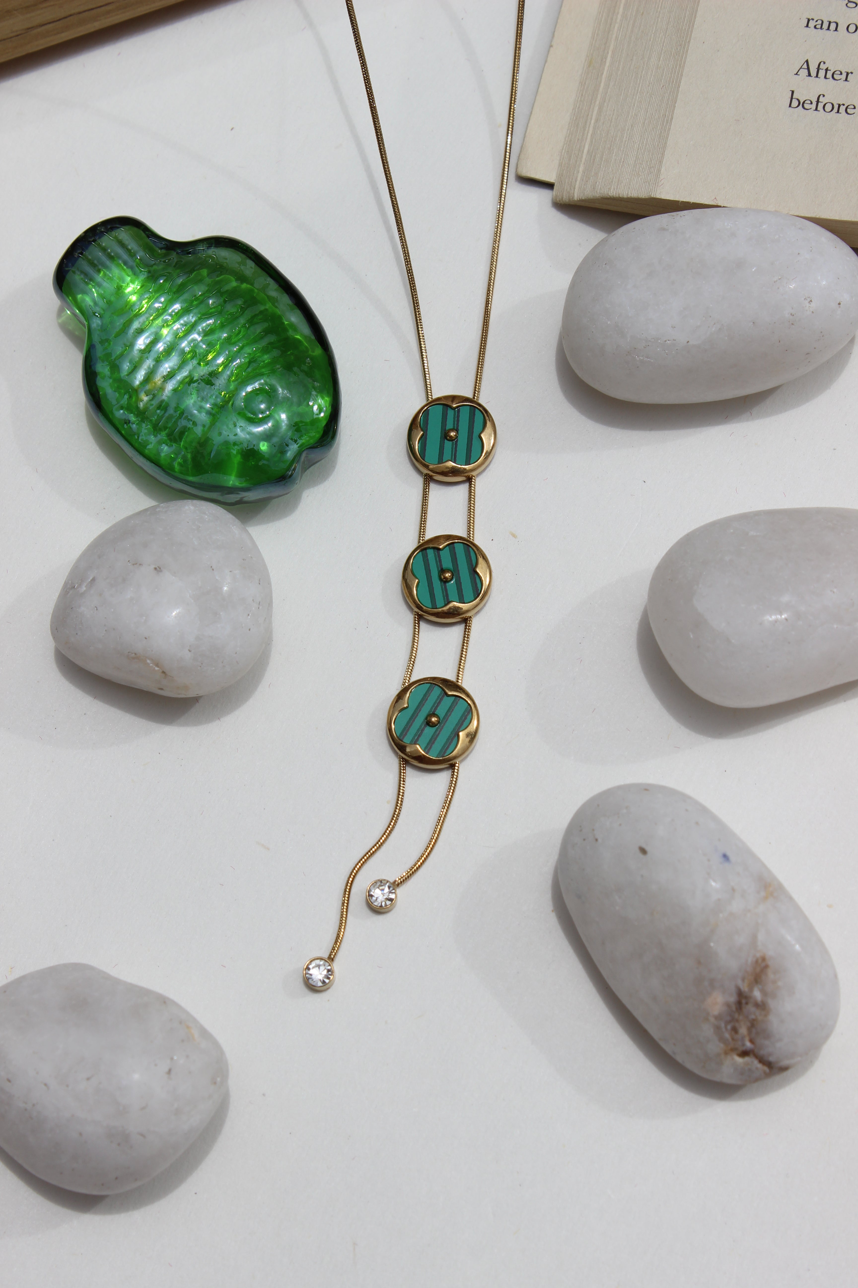 Green Mirage Necklace on a white surface with rocks