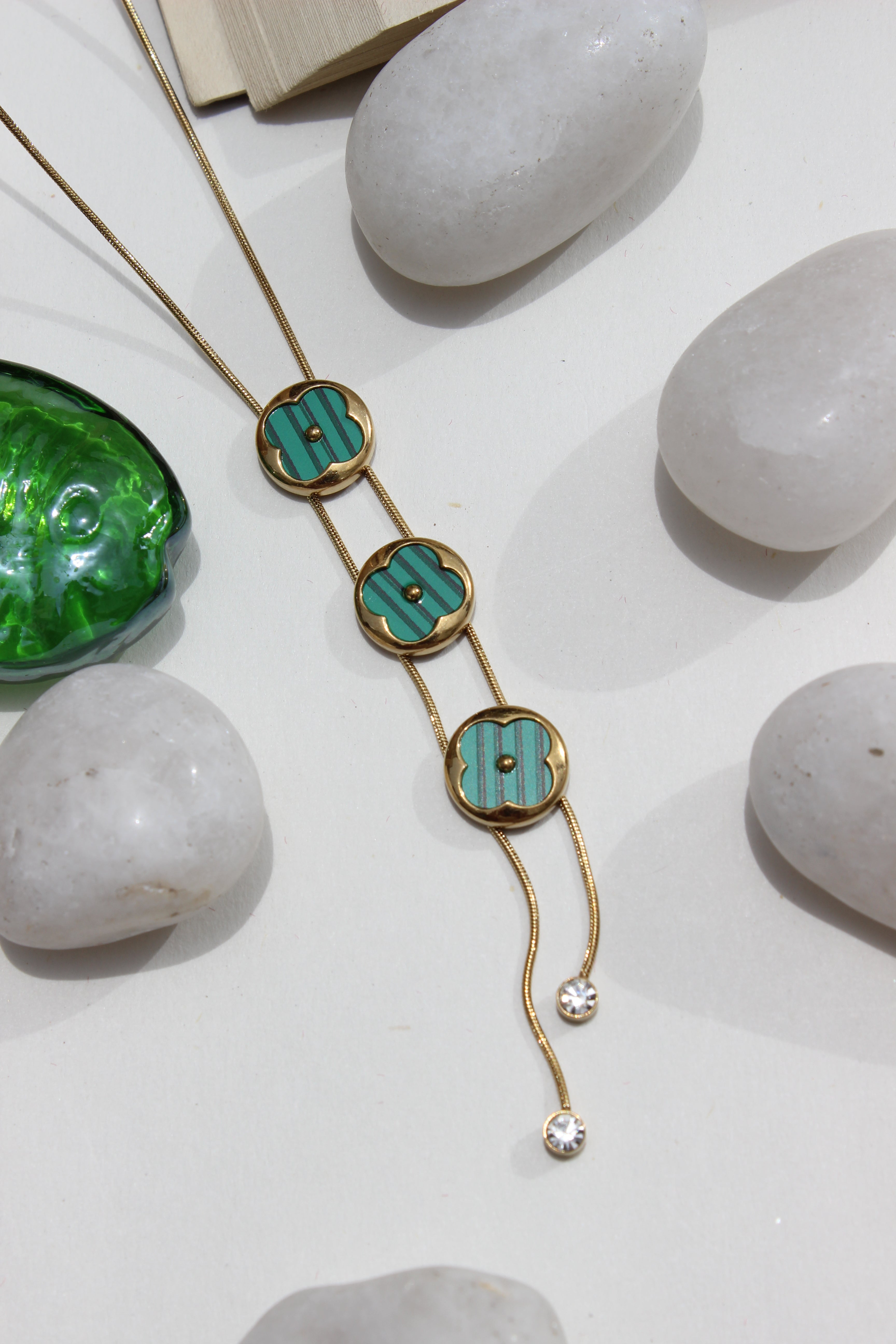 Green Mirage Necklace on a white surface with stones