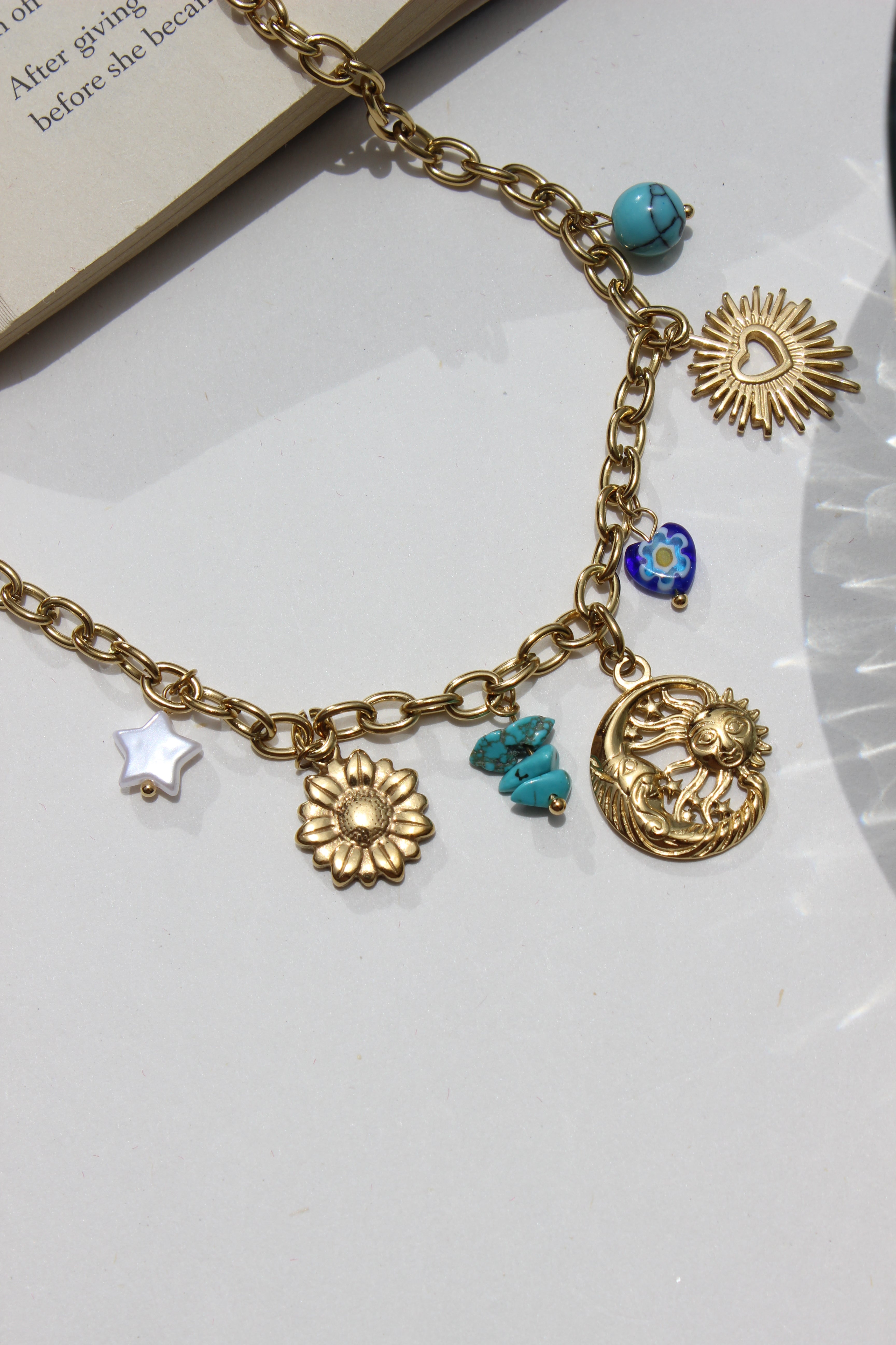 Solaris & Selene Charms Necklace with various charms on a white surface