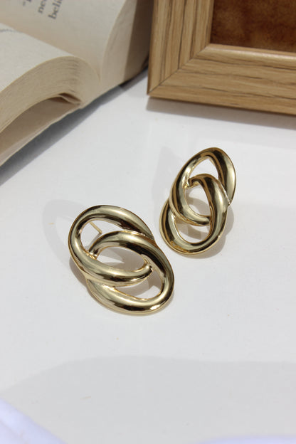 Daily Gleam Earrings on a light surface with a wooden frame in the background