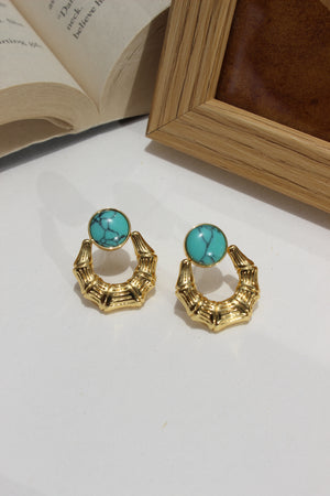 Azure Arc Earrings on a white surface next to an open book and wooden box