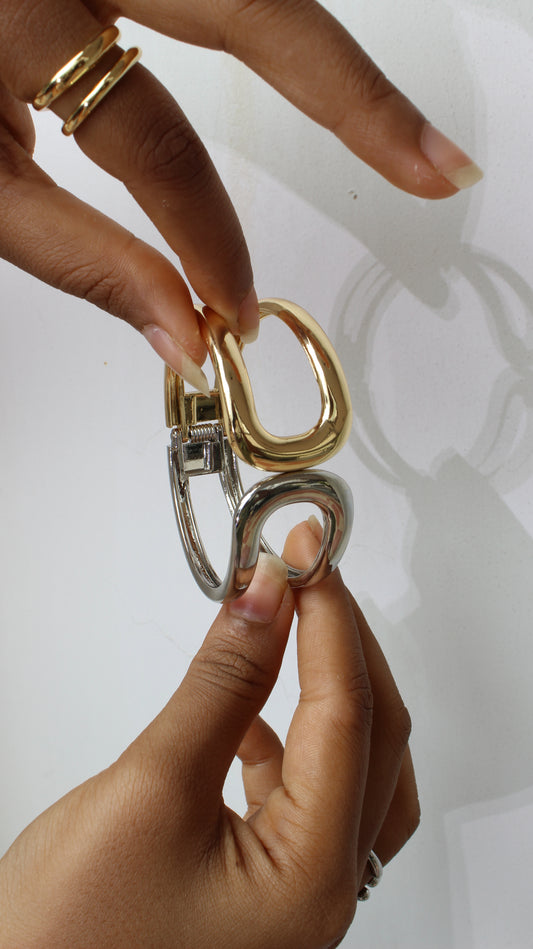 Close-up of hands holding a Soft Armour Bracelet on white background
