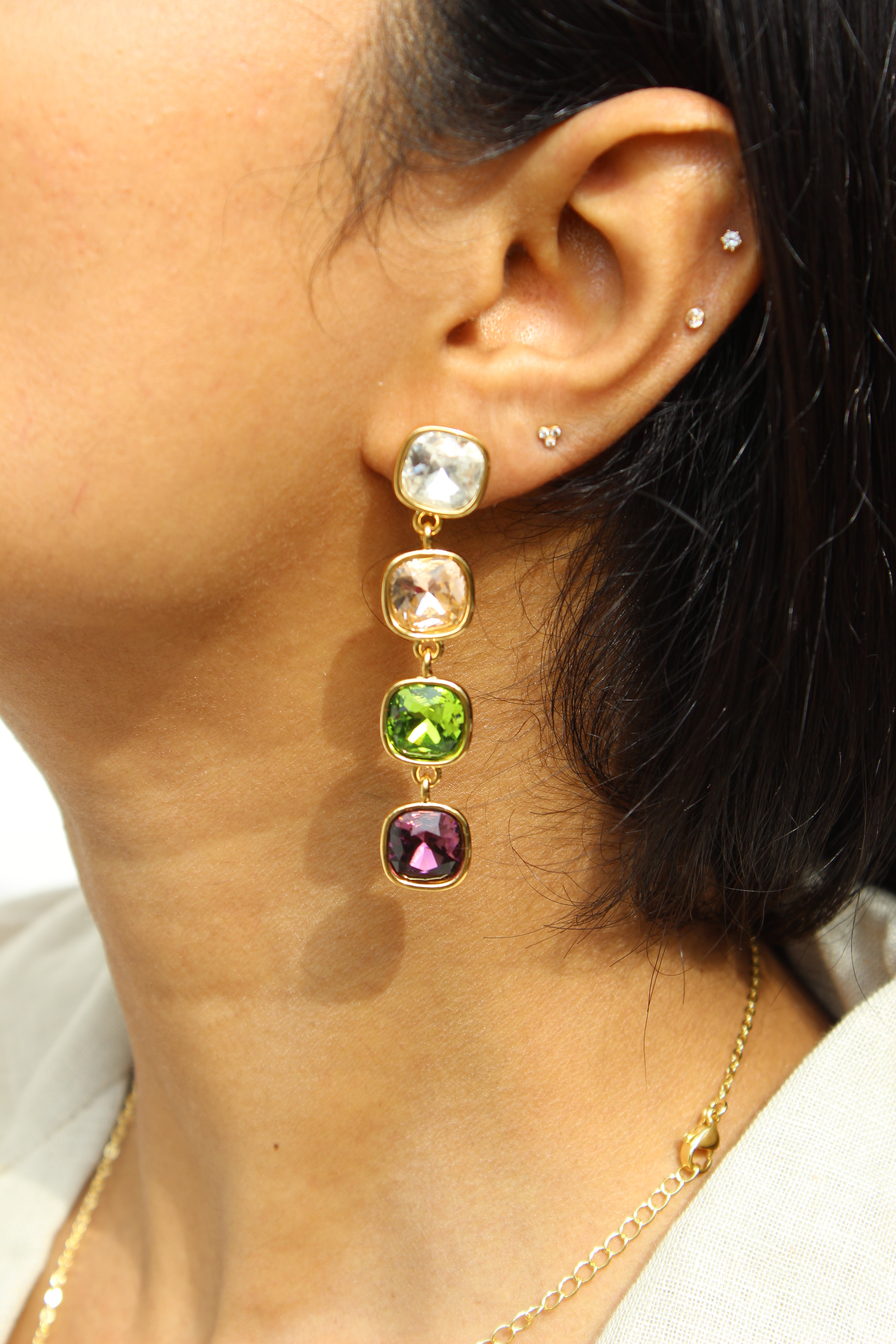 Close-up of an ear with a Moonkiss Drop Earrings featuring multicolored gemstones