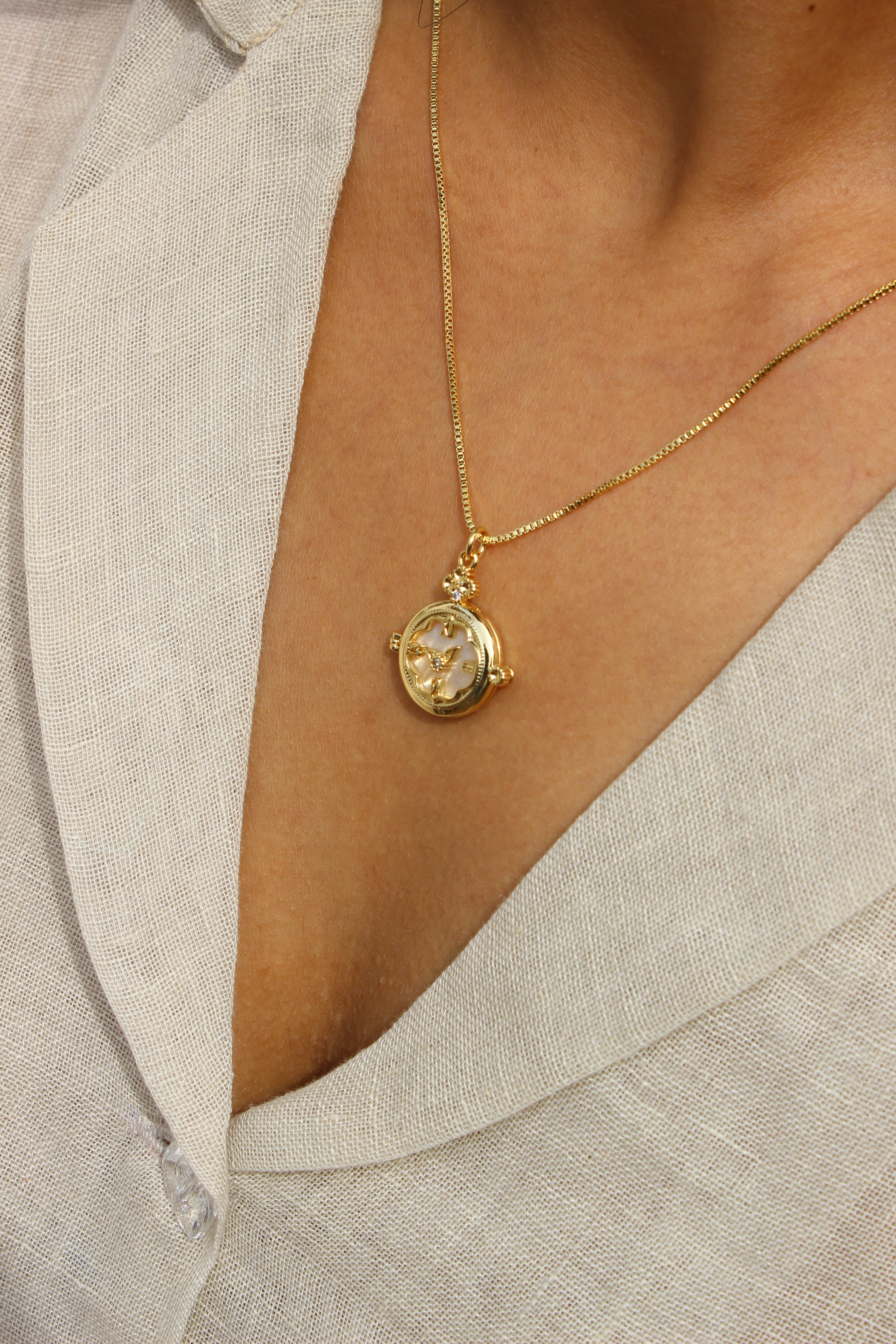 Whitespell Pendant Necklace on a person wearing a light-colored garment