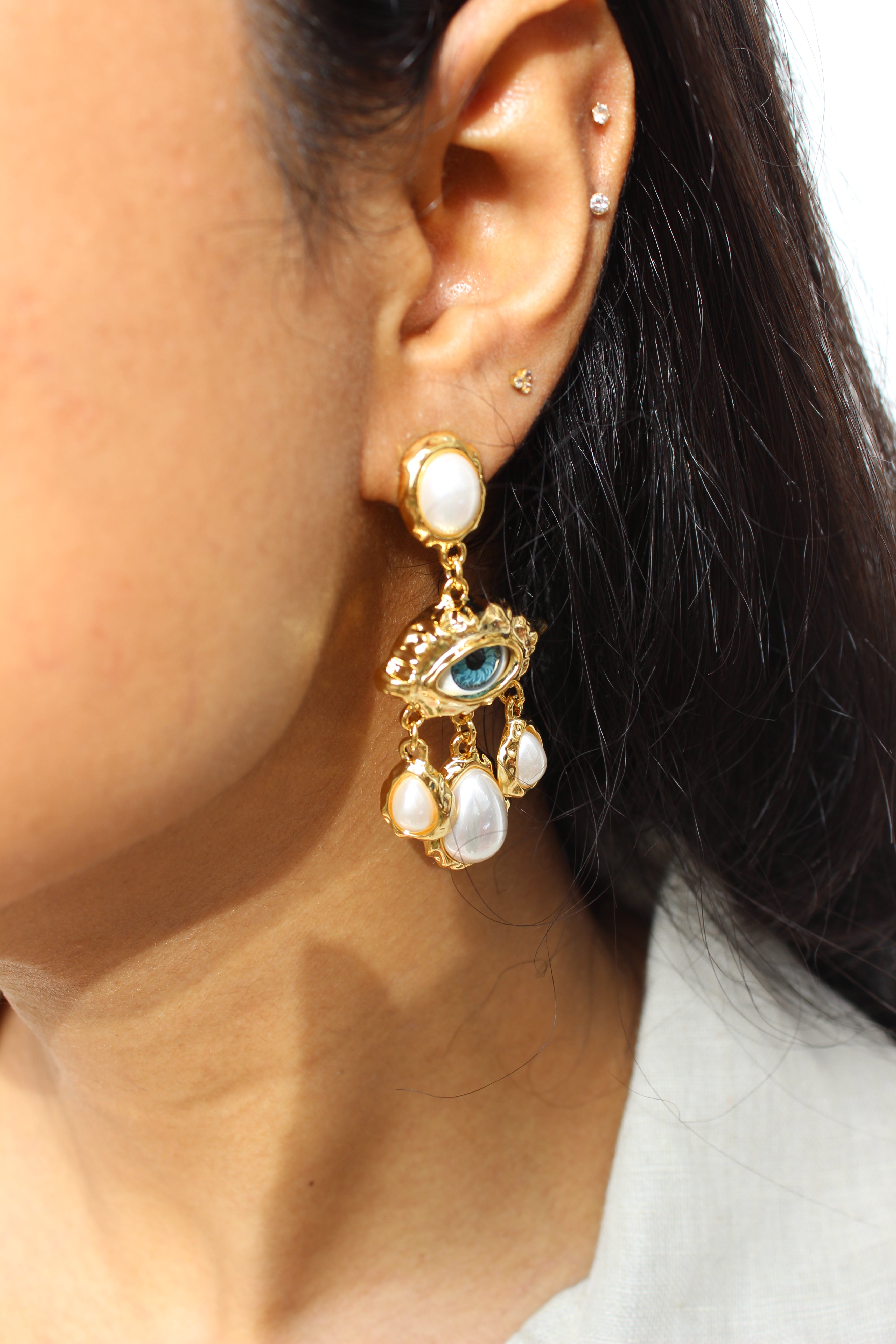 Close-up of a model Born of Sea Earrings with gemstones