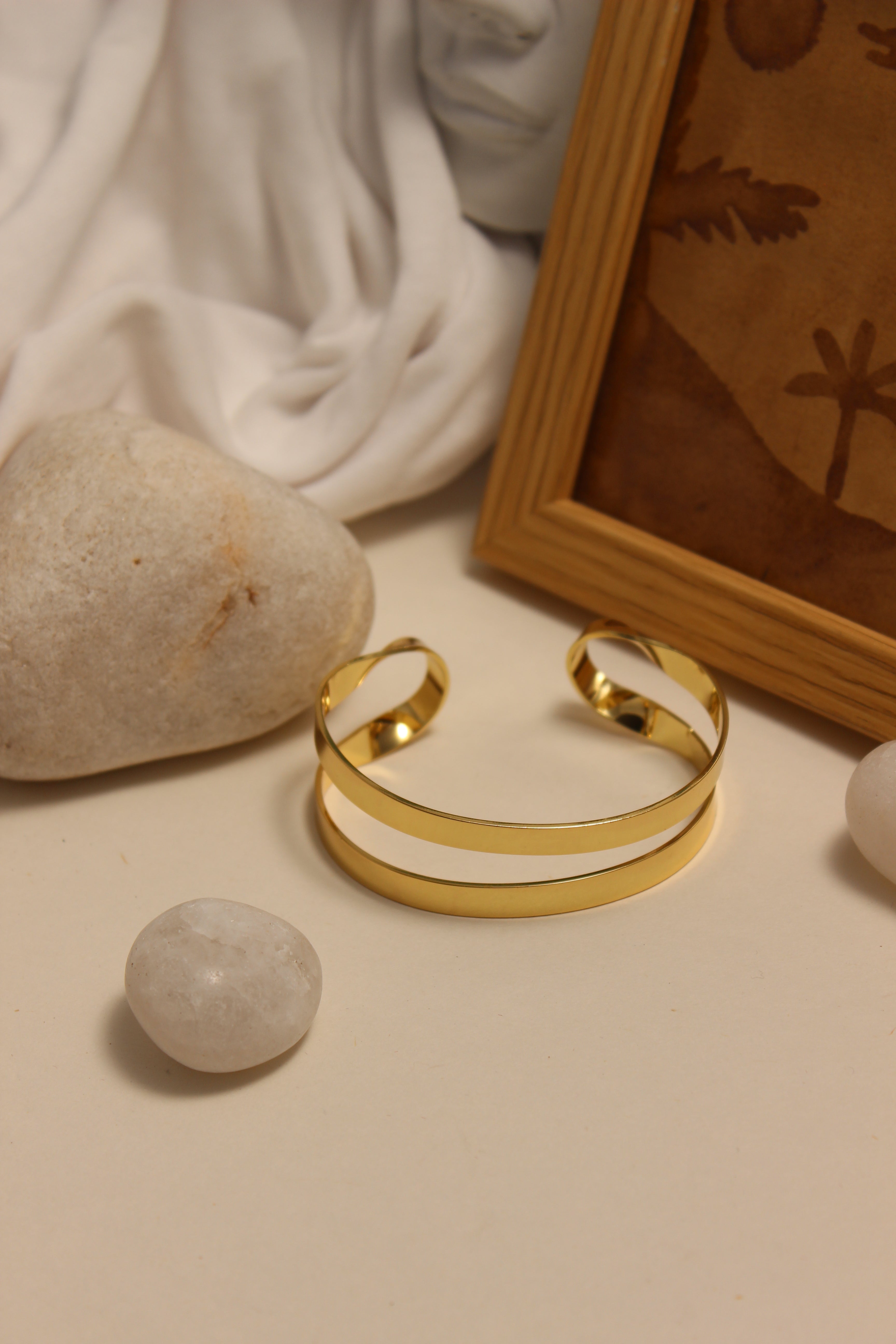 Monarch Cuff Bracelet on a neutral background with stones and fabric