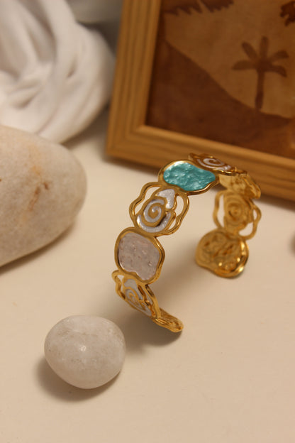 Pearled Blossom Cuff Bracelet on a beige surface with stones and fabric
