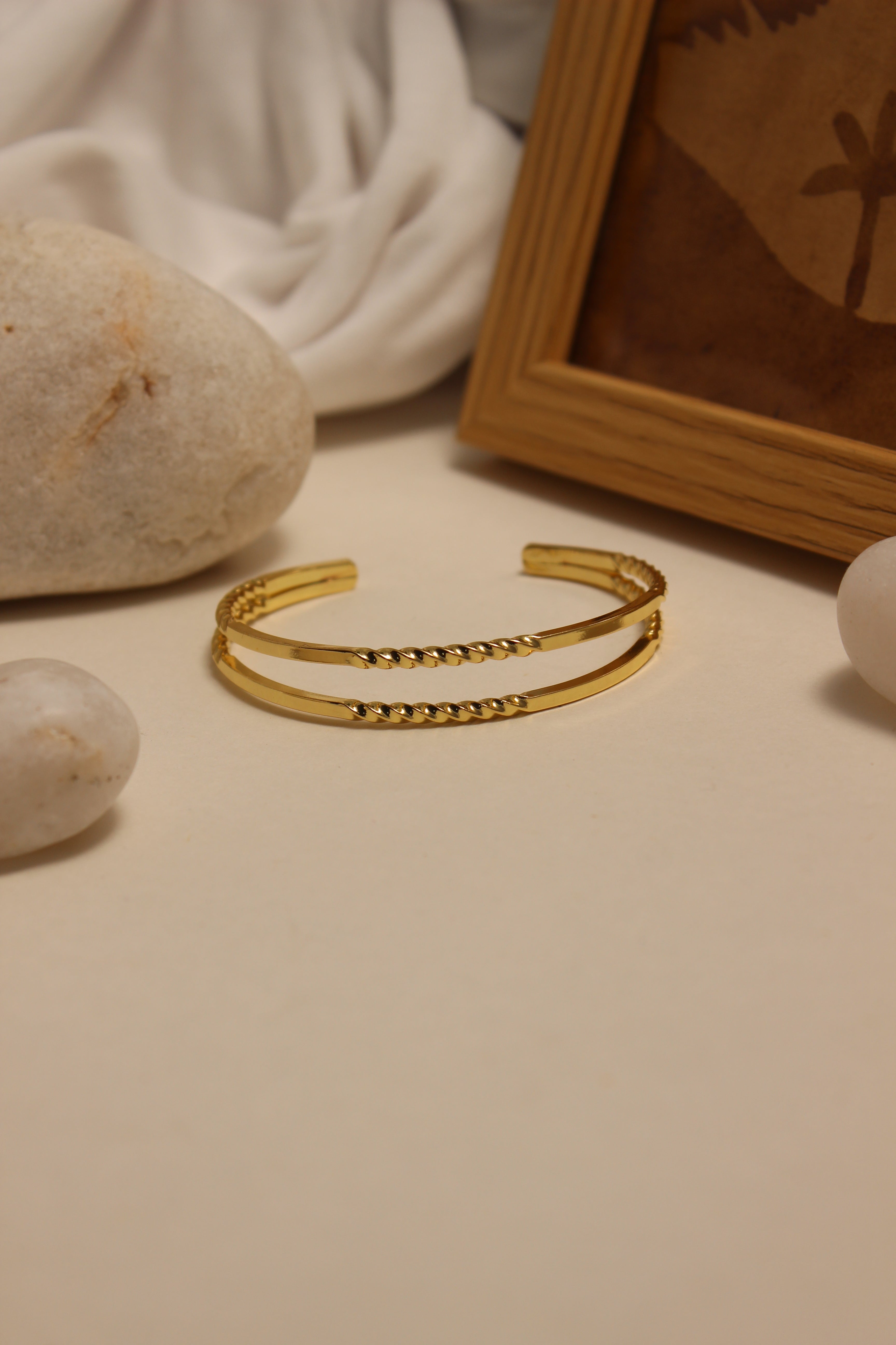 Loom Cuff Bracelet on a textured surface with a framed picture in the background