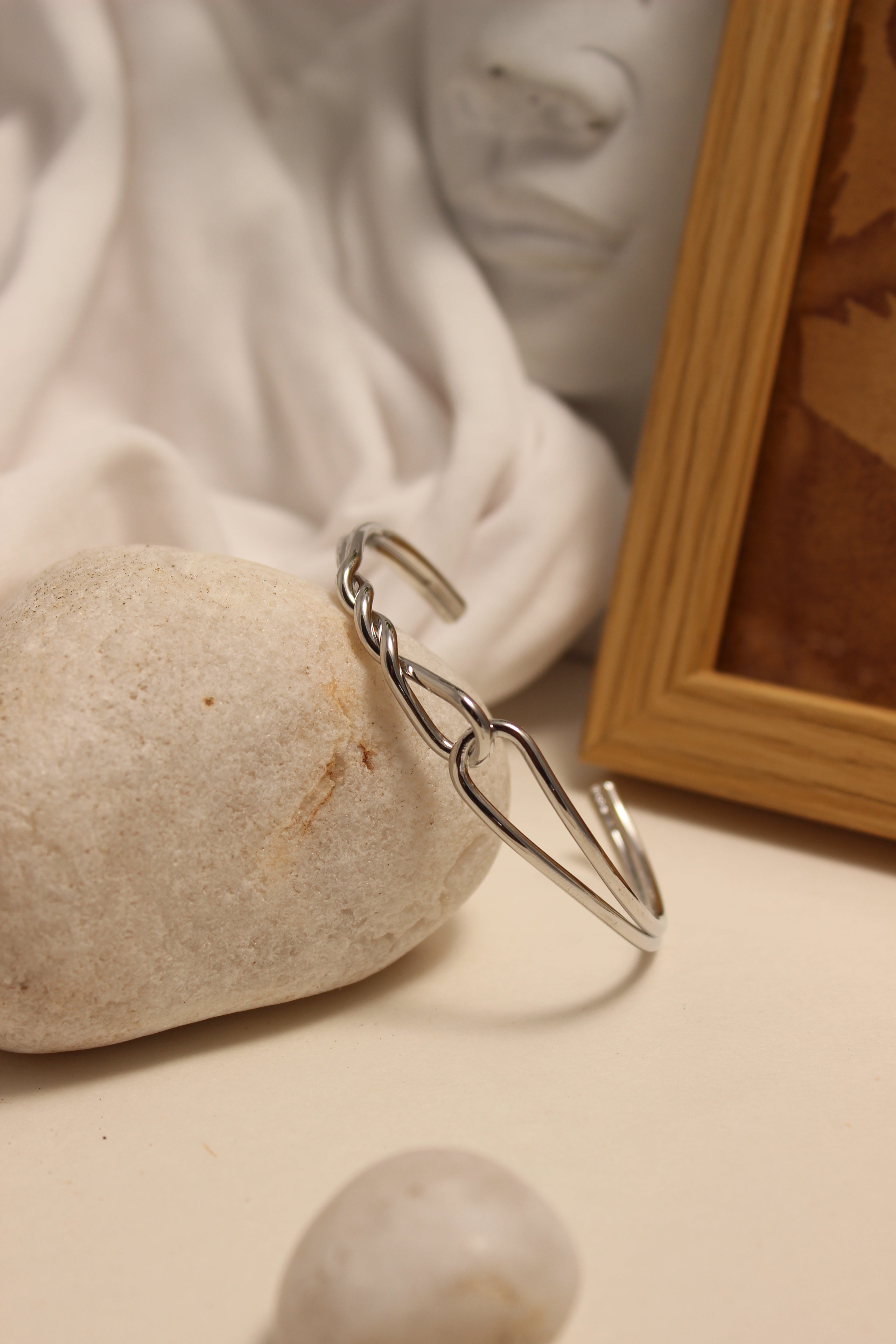 Sterling Dualis Cuff Bracelet on a stone with a blurred background