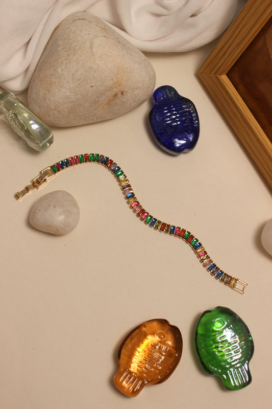 Jeweltone Bracelet on a beige surface with decorative stones and a wooden frame