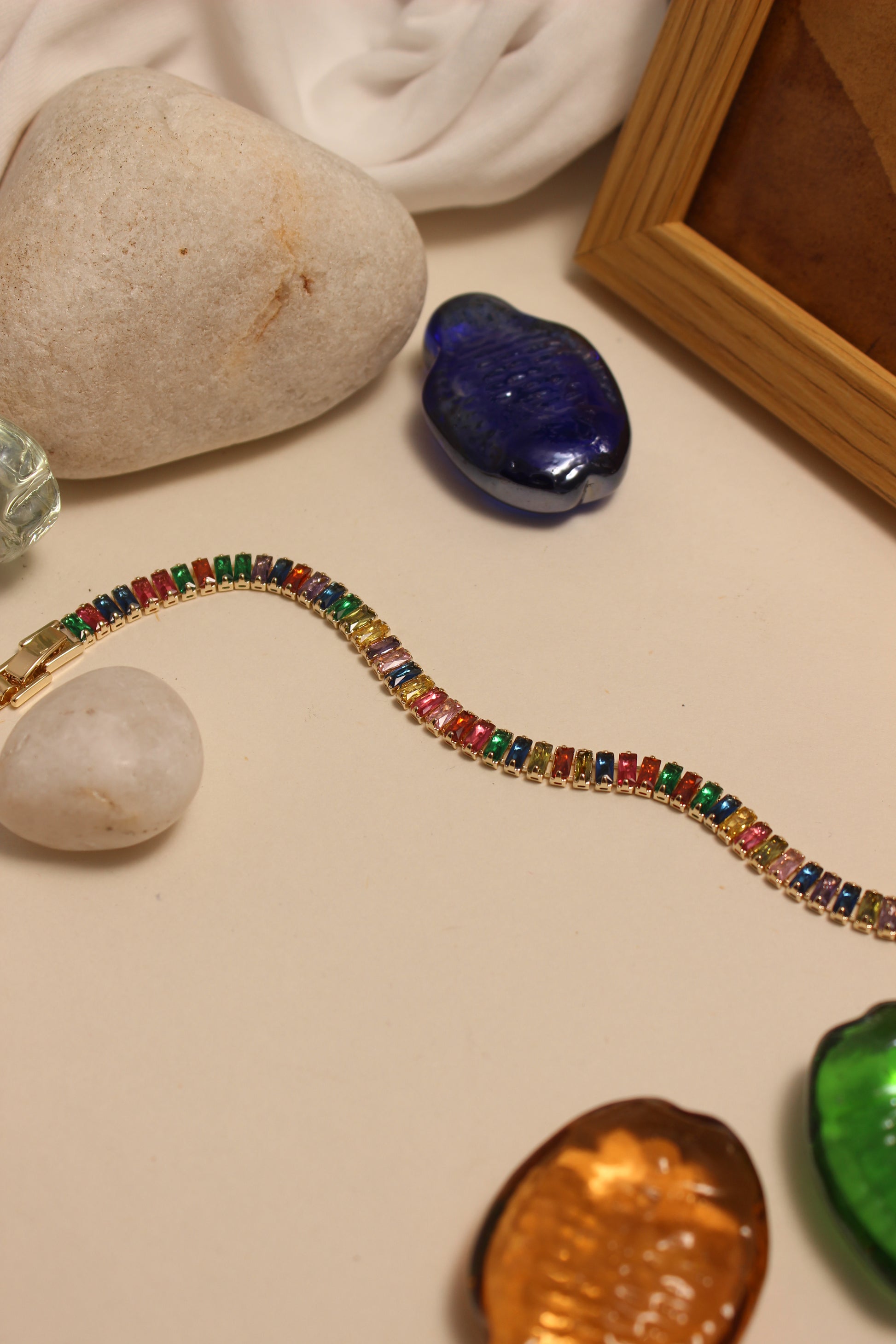 Jeweltone Bracelet on a neutral surface with stones and seashells
